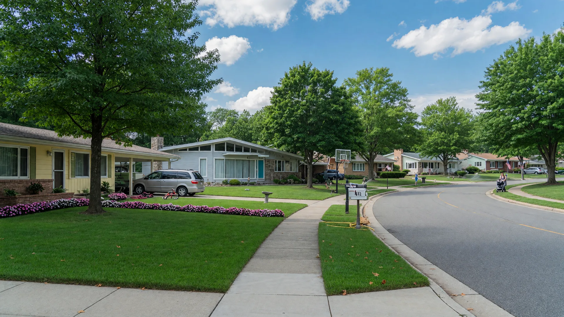 Quiet suburban residential street in Willingboro NJ with ranch and mid-century modern homes and mature shade trees on a bright summer day