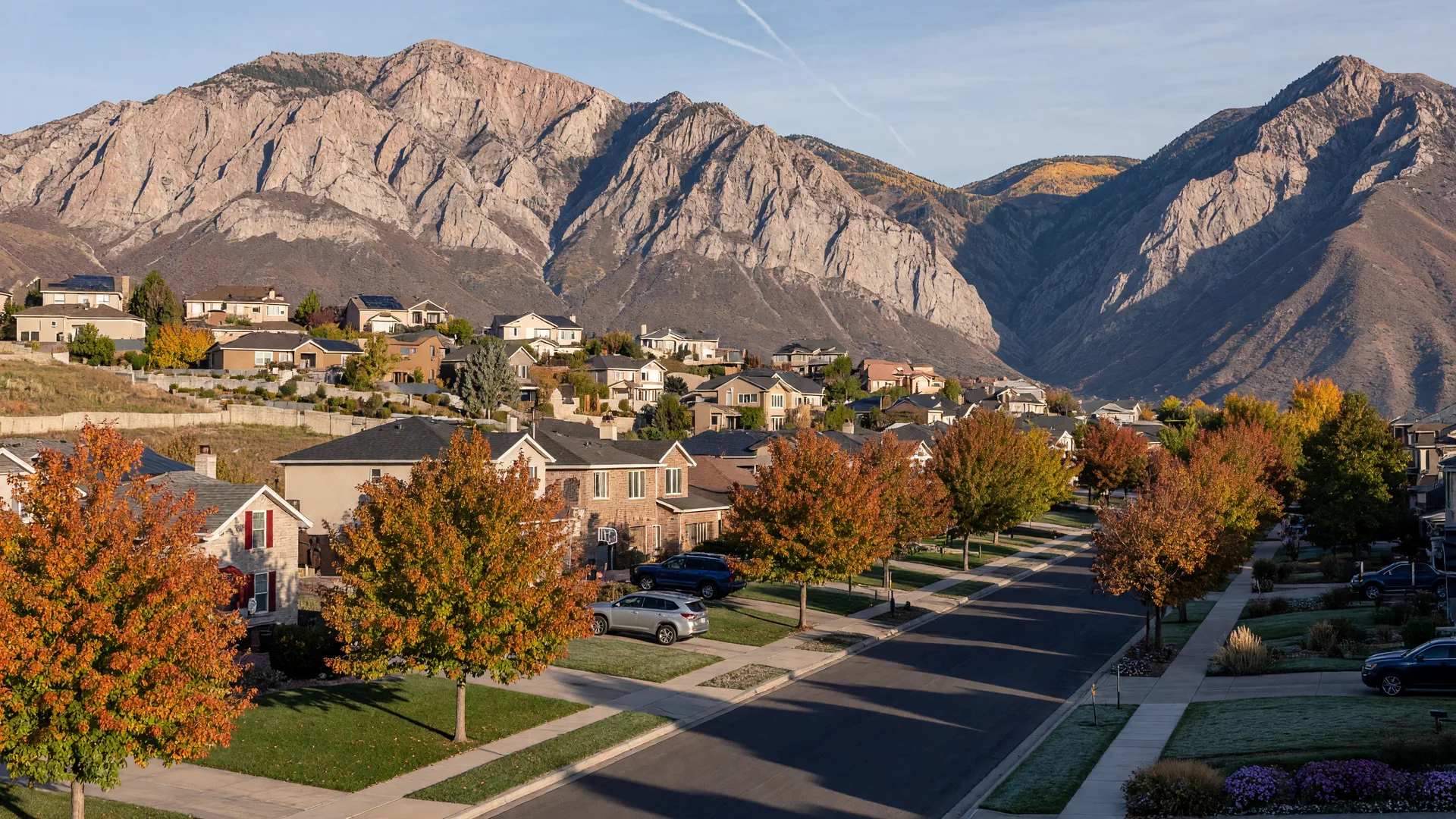 Morning light over the east bench suburbs of Sandy and Draper, homes climbing the foothills beneath the granite walls of the Wasatch range.