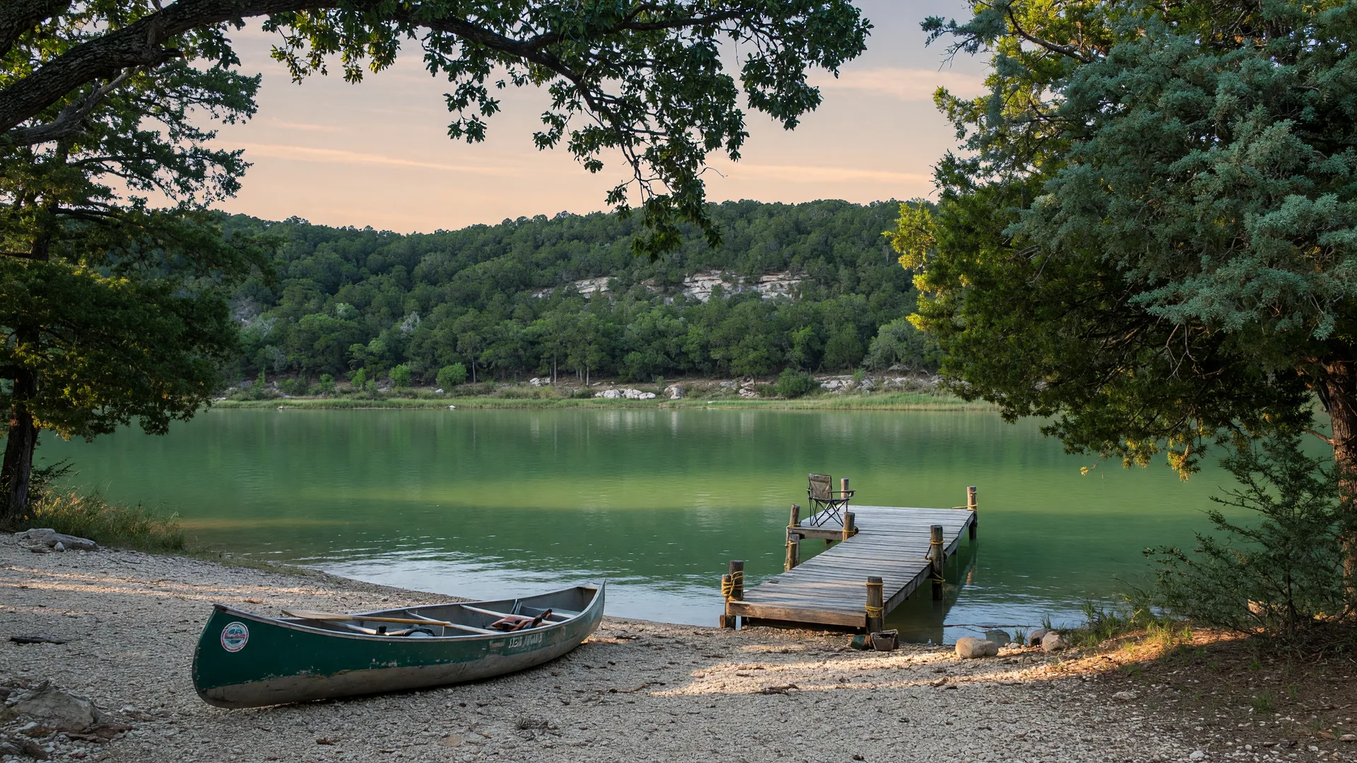 Stillhouse Hollow Lake in late afternoon light with a wooden dock and overhanging trees