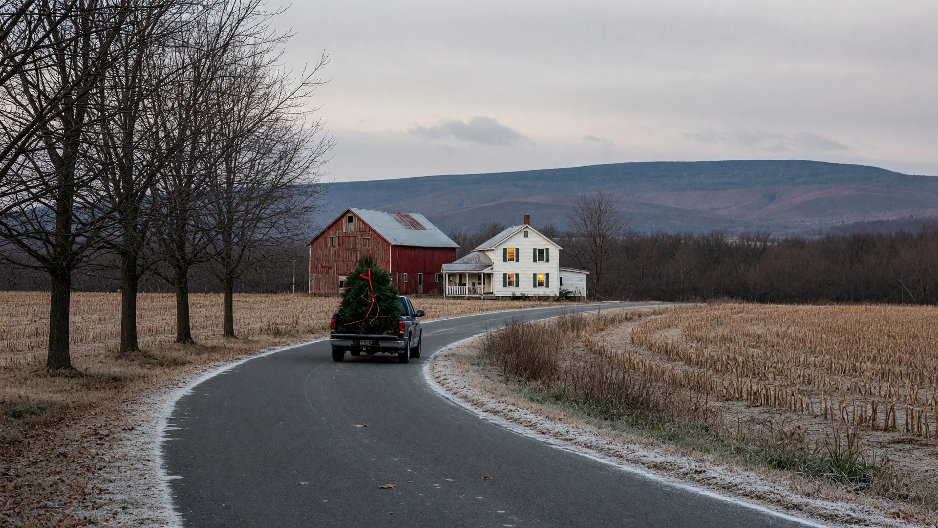 Frost on a Lehigh Valley country lane in mid-November with bare maples, a red barn and white farmhouse with a warm glowing window, and the Blue Mountain ridge on the horizon