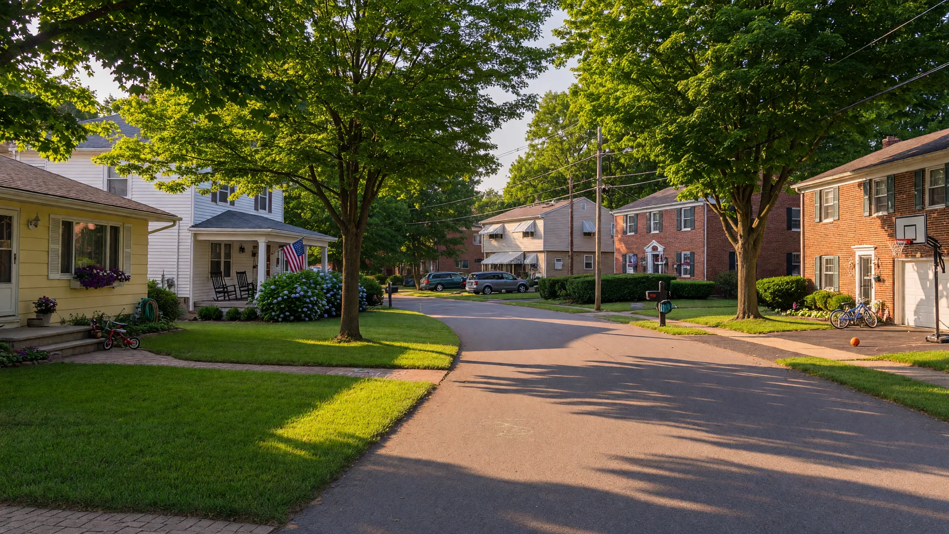 Quiet residential street in Amherst, Ohio with traditional and mid-century homes on a sunny summer afternoon