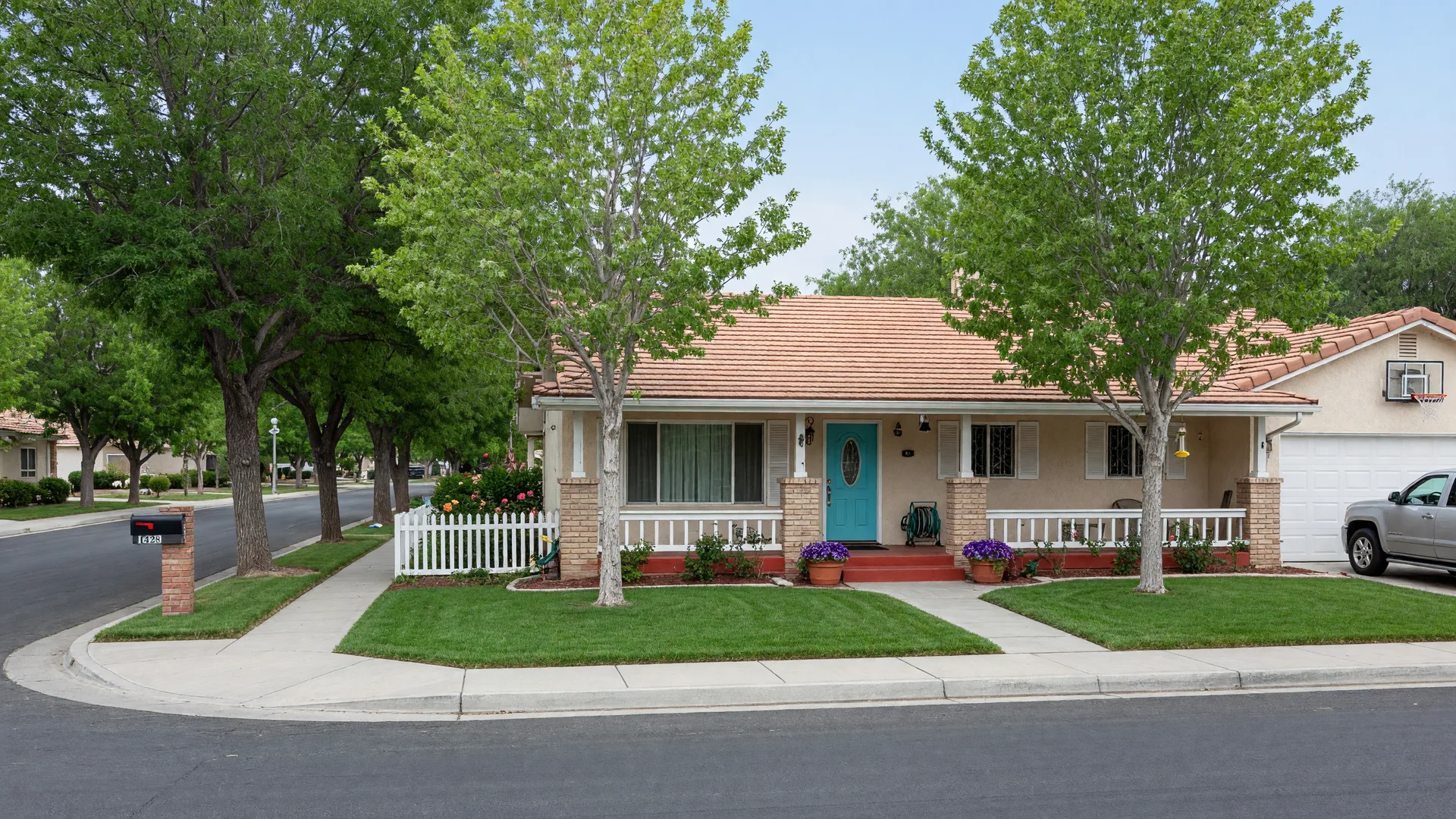 A classic Nevada ranch-style home on a tree-lined street in bright daylight with a well-kept lawn and welcoming entry.