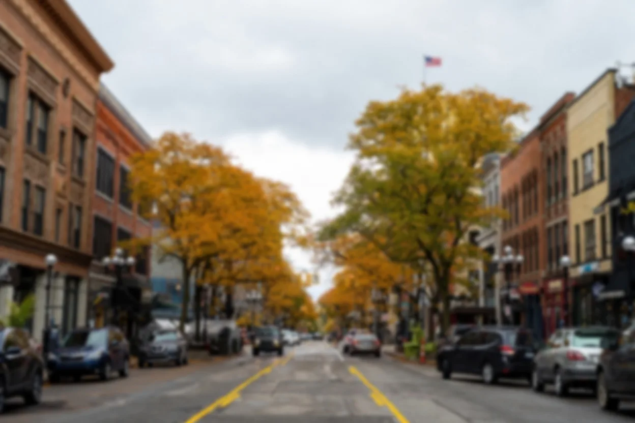 A softly blurred downtown street scene at dusk, kept gentle and behind the text