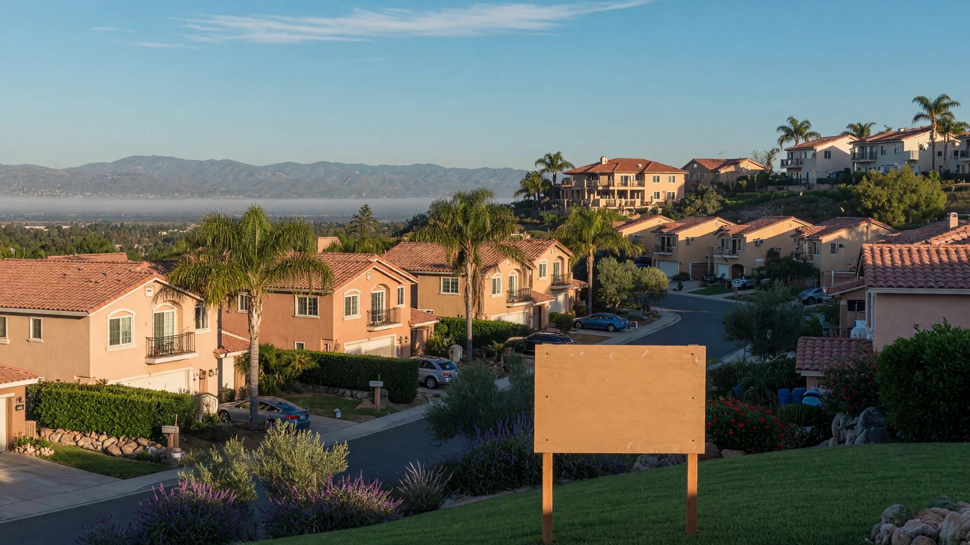 A Murrieta hillside neighborhood on a clear October morning with tile-roofed stucco homes, palm trees, golden light, and distant mountains