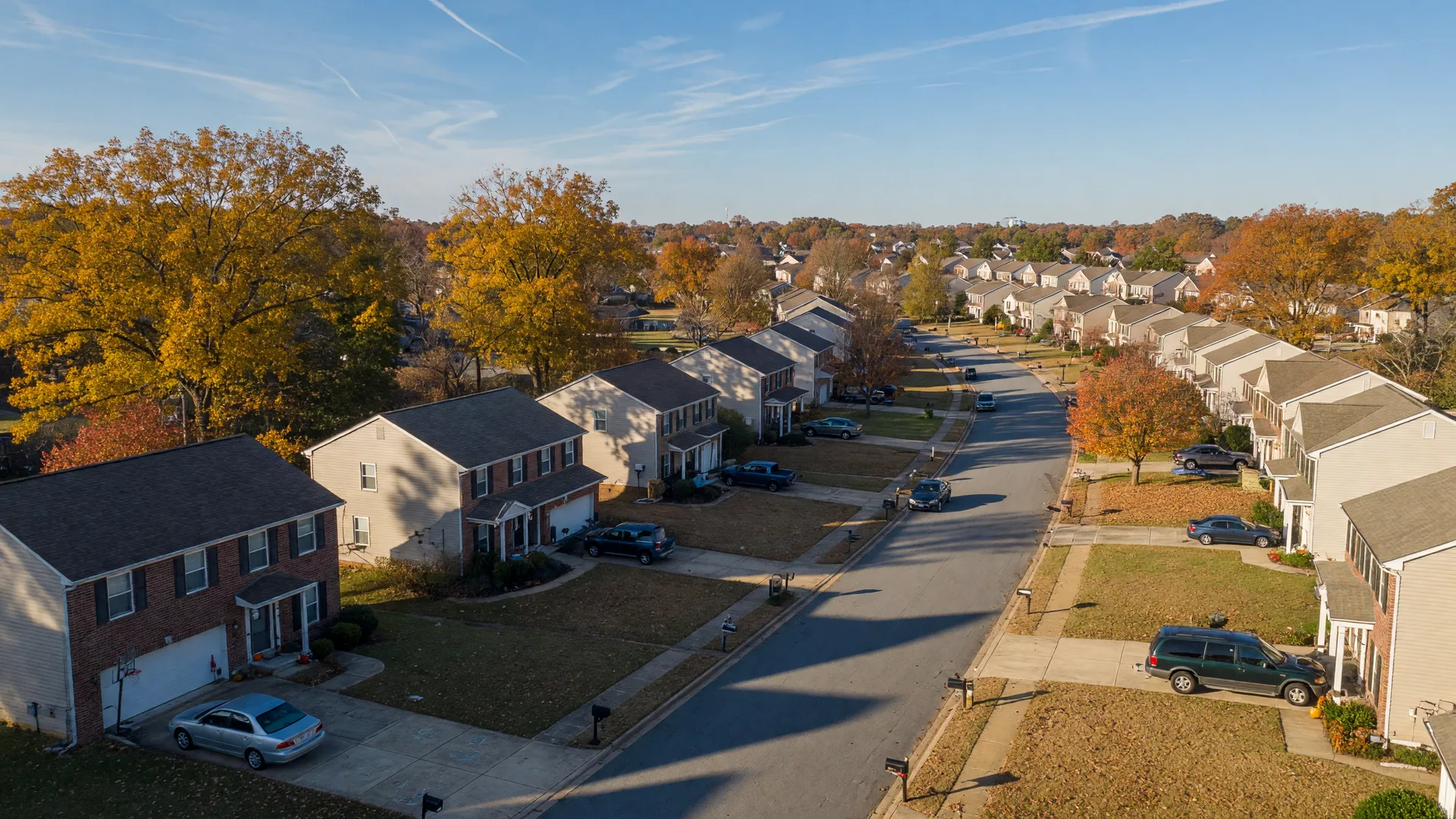Low aerial view of a sprawling Metro Atlanta suburban neighborhood in autumn with rows of single-family homes
