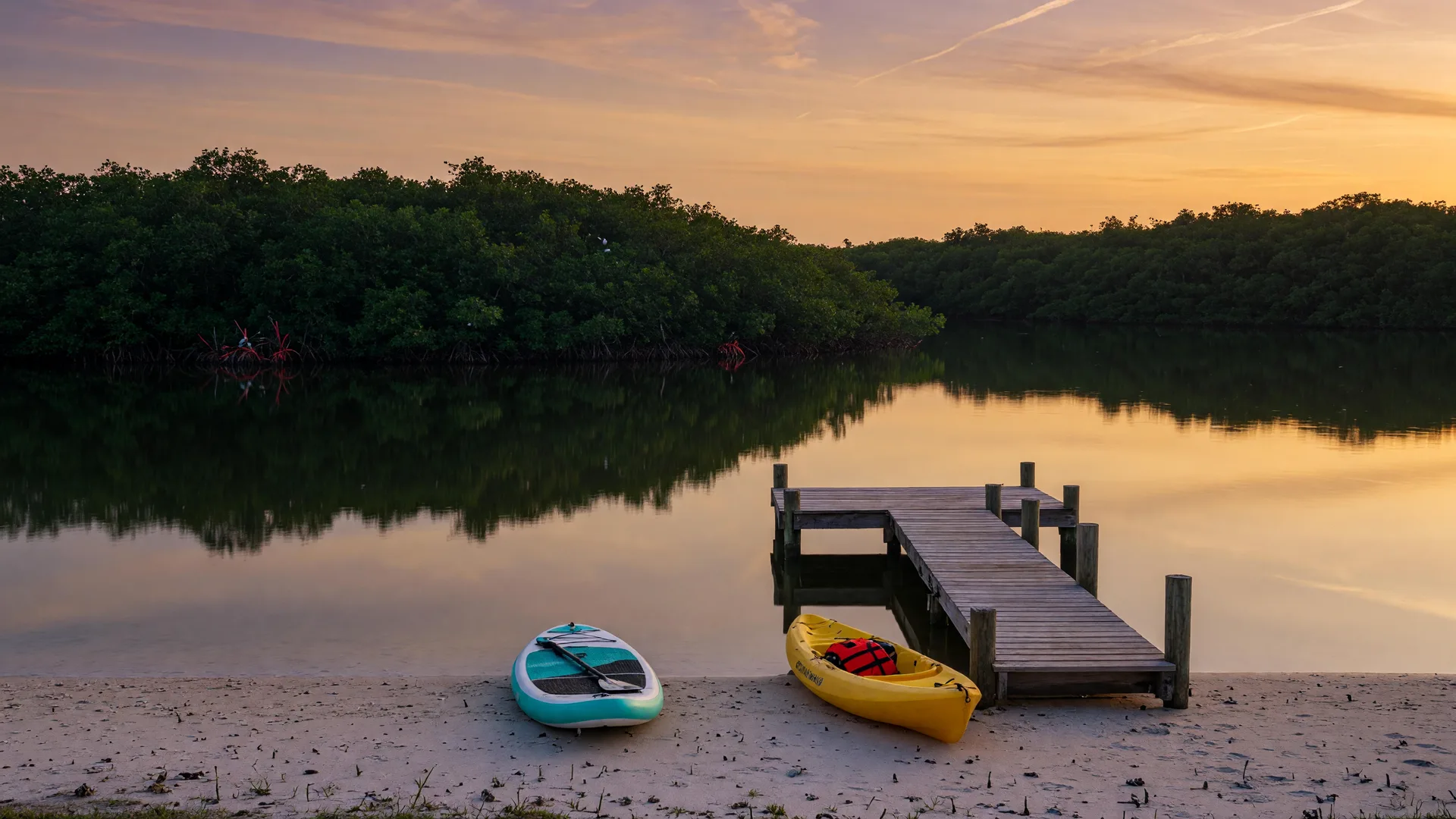 Calm lagoon water, mangroves and a dock at Turtle Beach's Blind Pass side