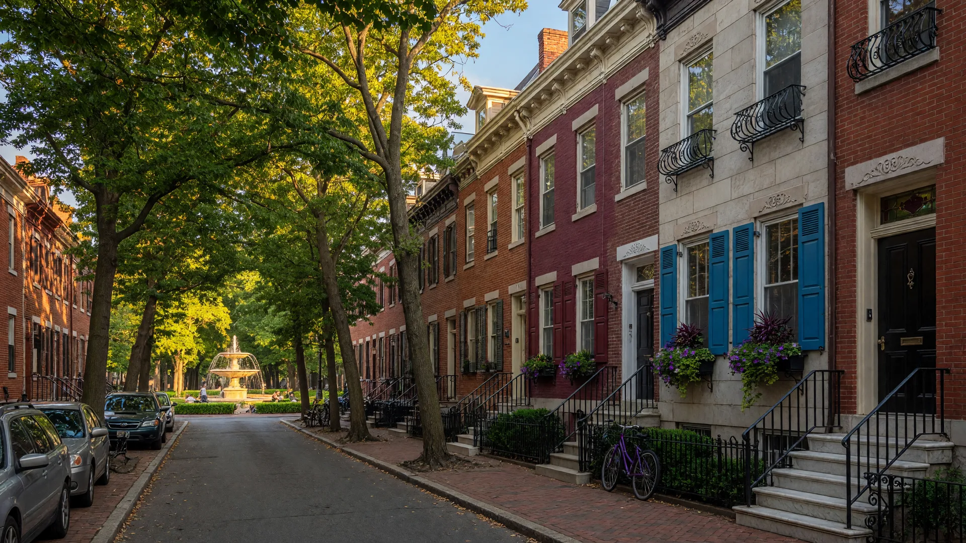 Historic Philadelphia row homes on a tree-lined street in Fitler Square with warm golden hour light