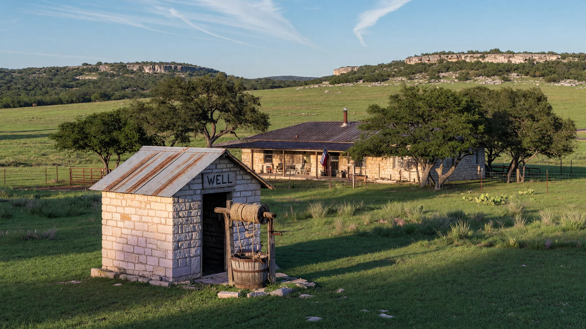 A limestone wellhouse with a metal roof on a Hill Country acreage ranch property