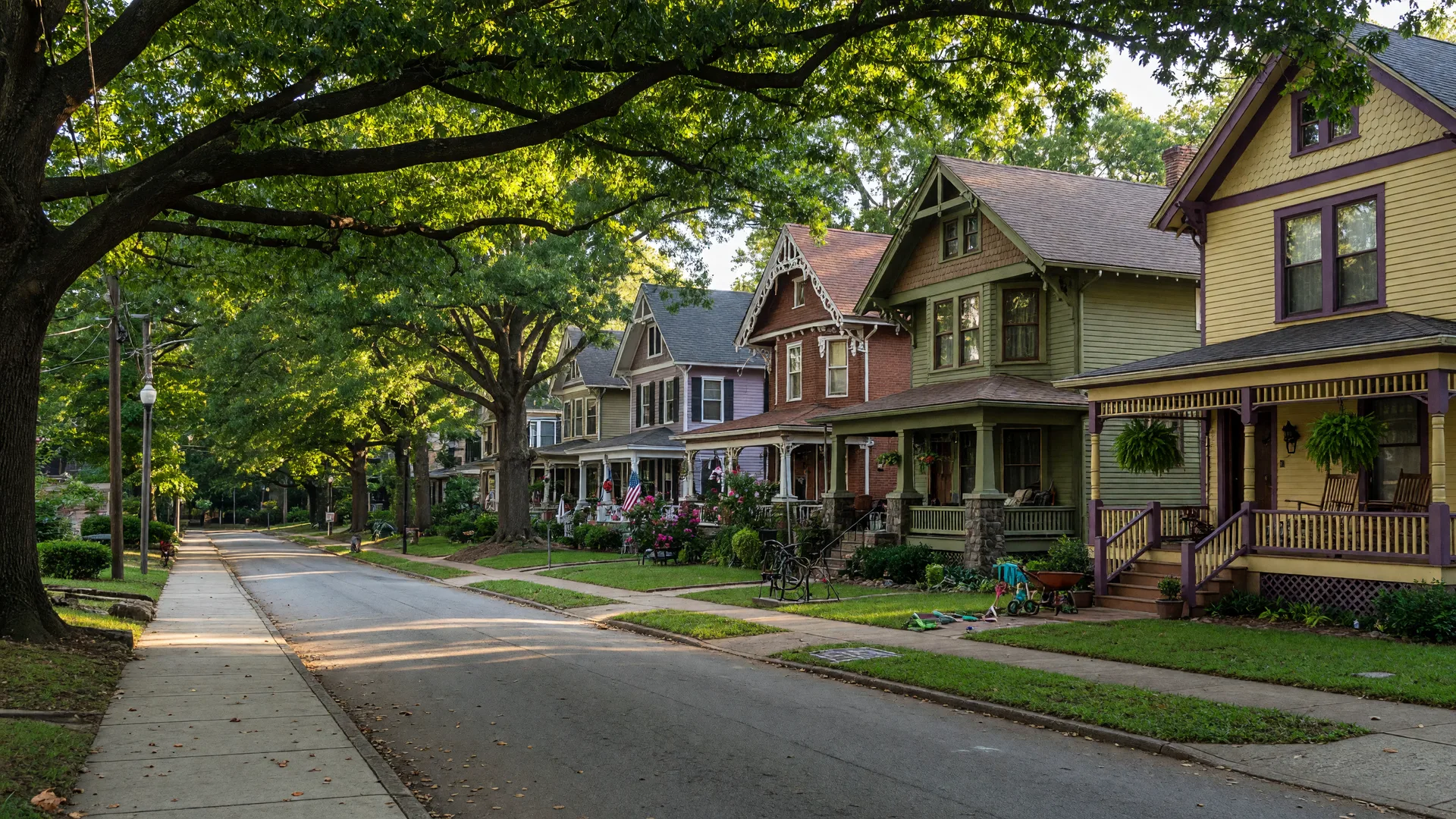 A tree-lined Inman Park street of restored Victorian and Craftsman homes with wide porches