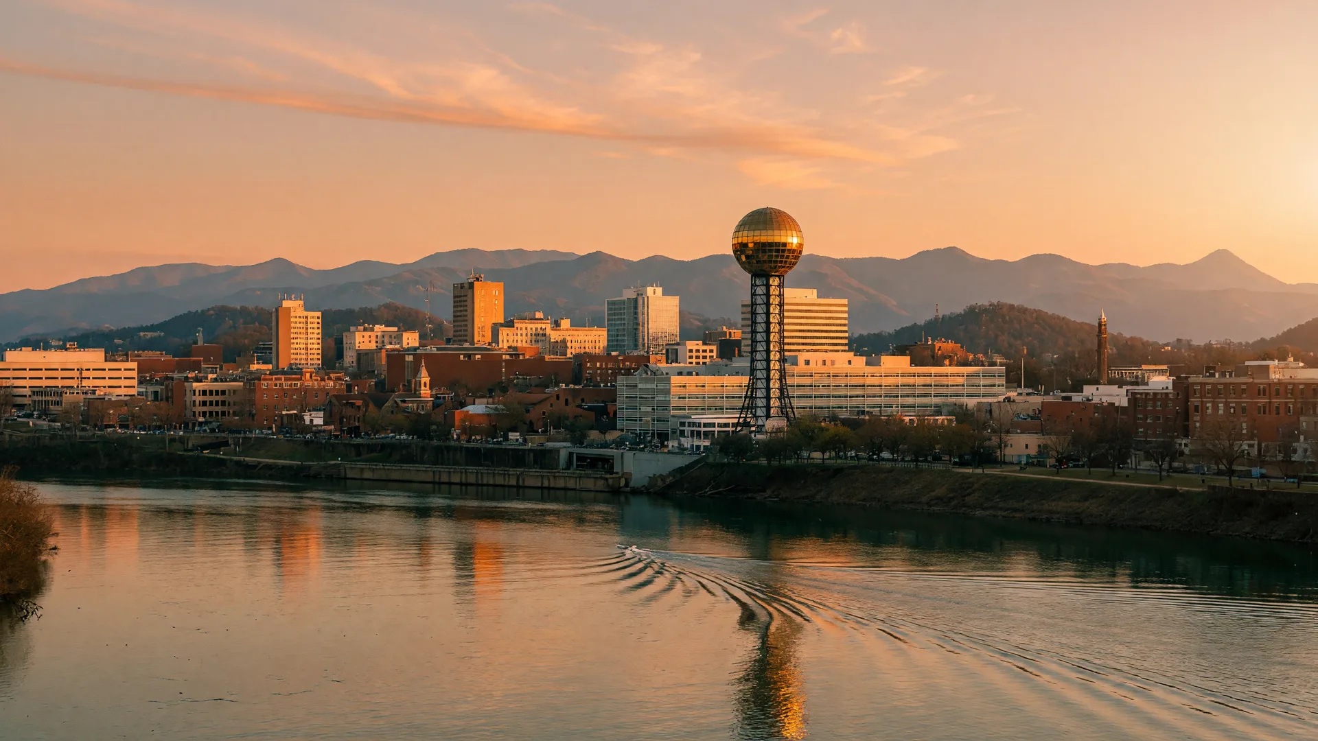 The Tennessee River and Knoxville skyline with the Sunsphere rising above downtown and the Smoky Mountains on the horizon at golden hour