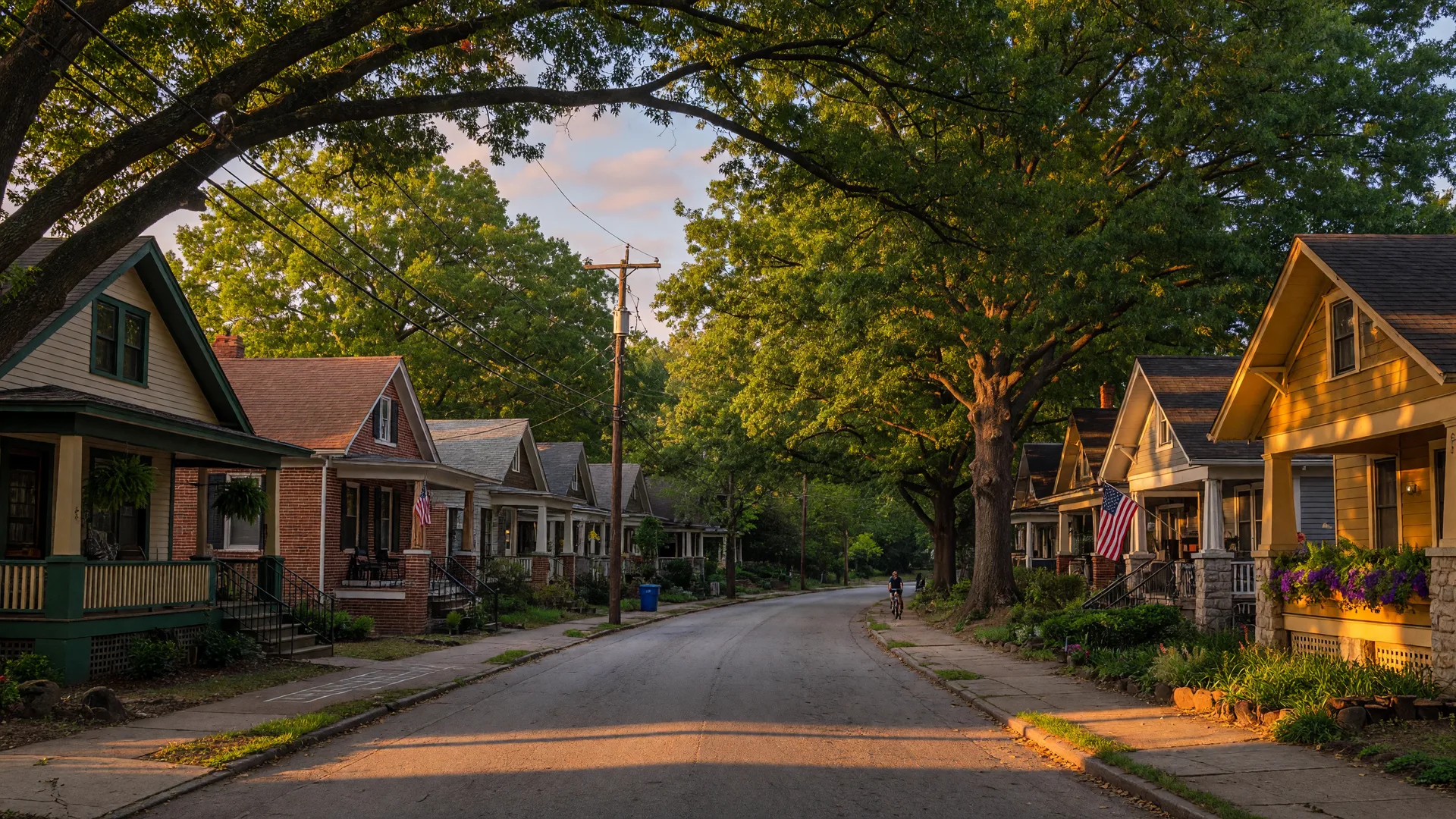 A tree-lined Atlanta intown street of craftsman bungalows with front porches at golden hour, representing the neighborhoods first-time buyers call home