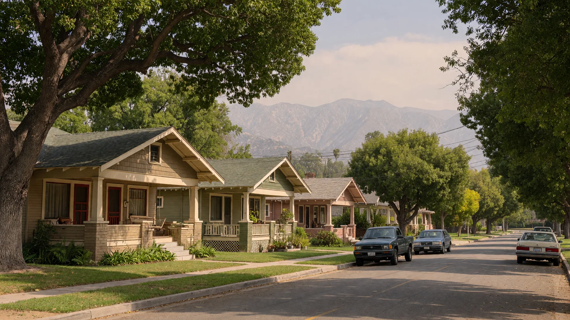 A tree-lined street of Craftsman bungalows in Lamanda Park, east Pasadena, with the San Gabriel Mountains hazy in the background