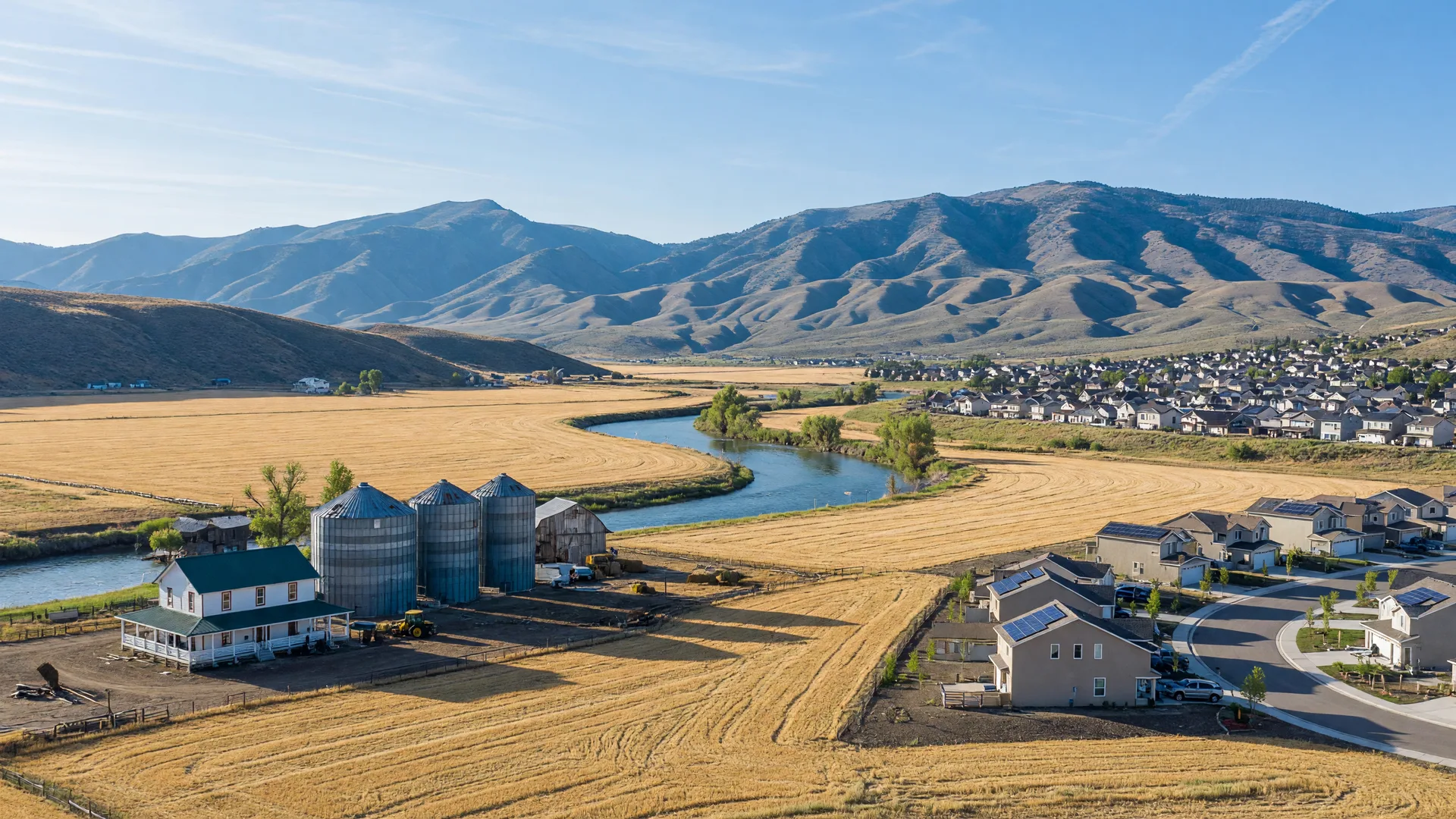 The small town of Star, Idaho beside the Boise River with a farmstead, fields, and mountains behind