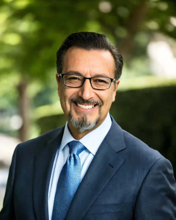 Daniel Racedo, San Fernando Valley real estate consultant at eXp Realty, smiling in a navy suit