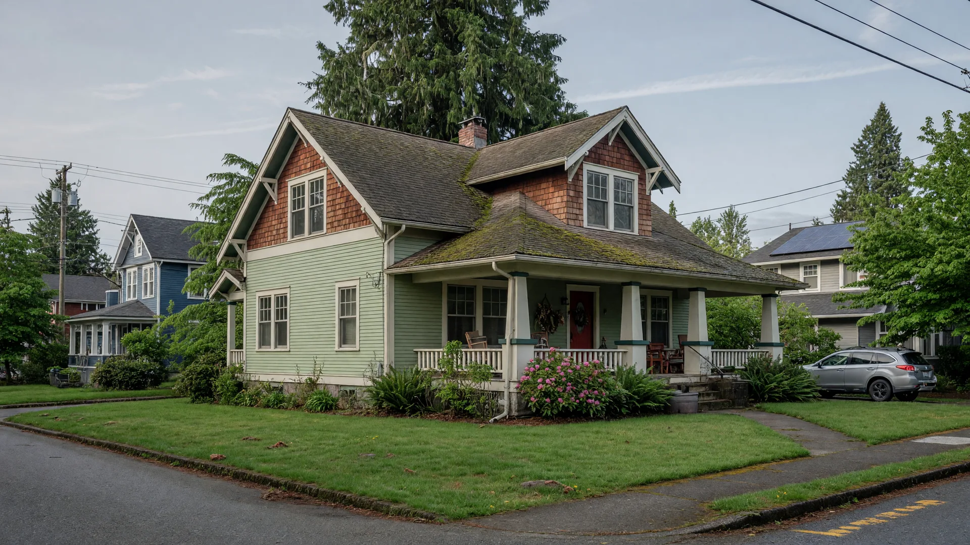 A classic craftsman-style single-family home with a covered porch and lush green yard on a tree-lined street in Snohomish County, Washington