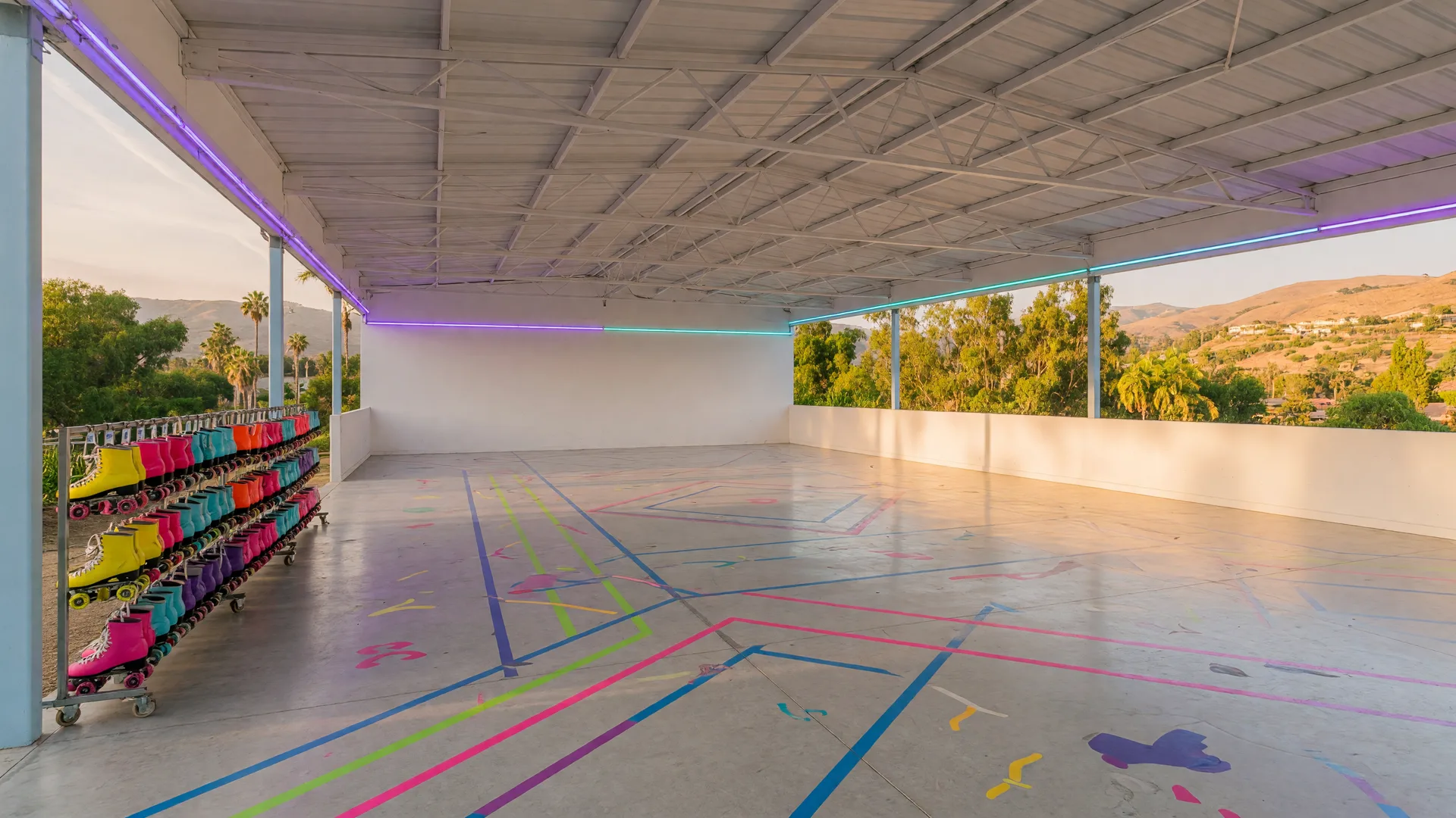 The modern covered roller-skating Sports Pavilion at Santa Clarita's George A. Carvalho Sports Complex with a polished skate floor and valley hills beyond