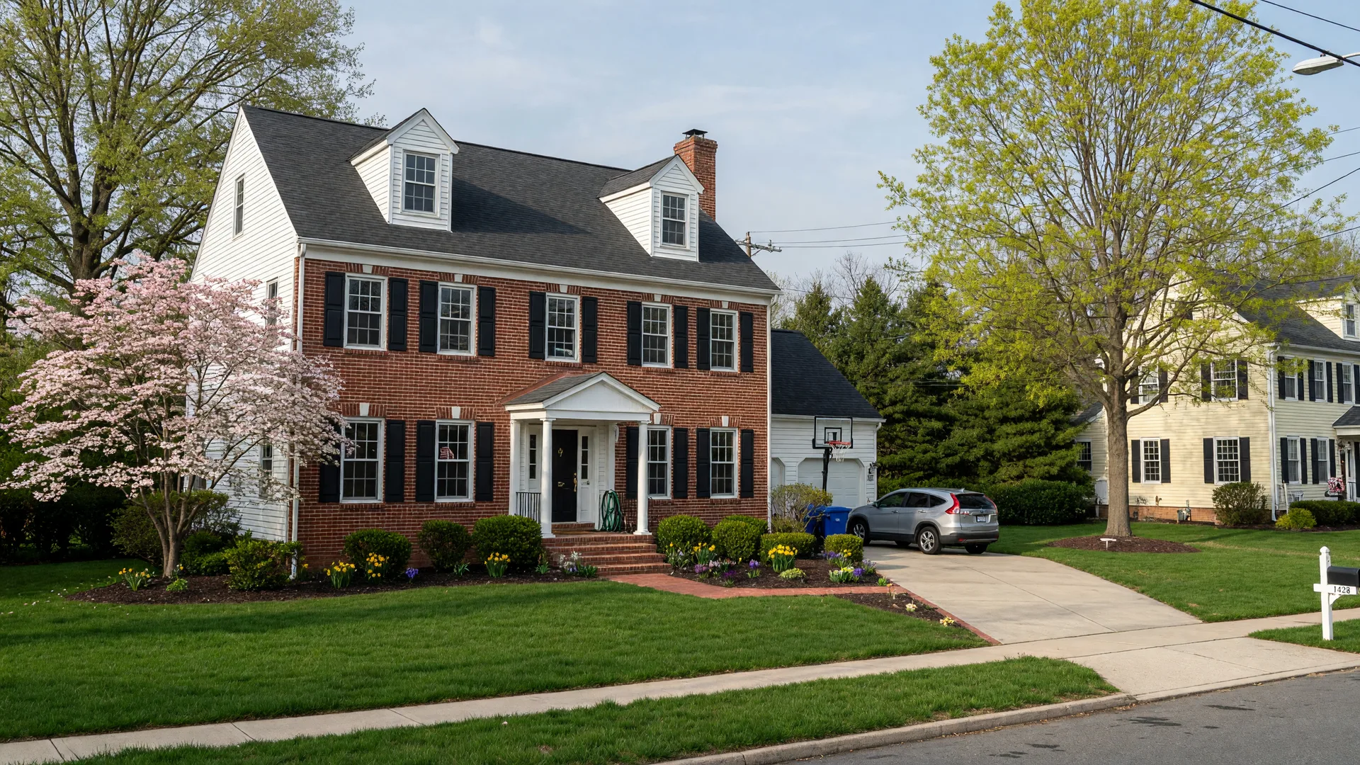 A well-maintained Maryland colonial home in a suburban neighborhood with brick facade, siding, and manicured lawn