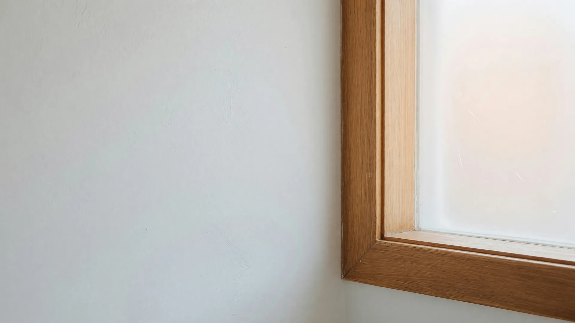 Soft daylight across a freshly painted wall and warm wood trim