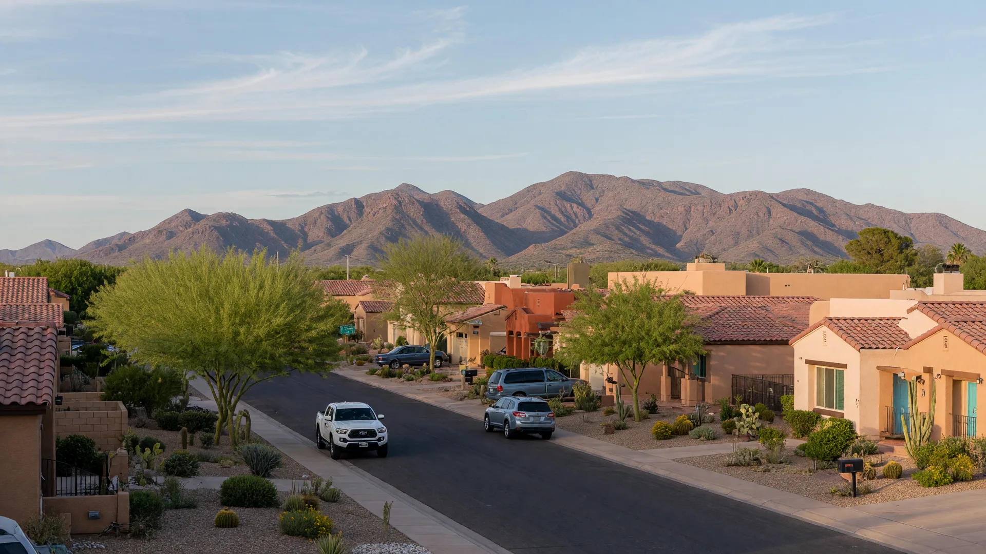 Quiet residential street in Gilbert, Arizona on a clear September morning with modern Southwestern homes and the San Tan Mountains on the horizon