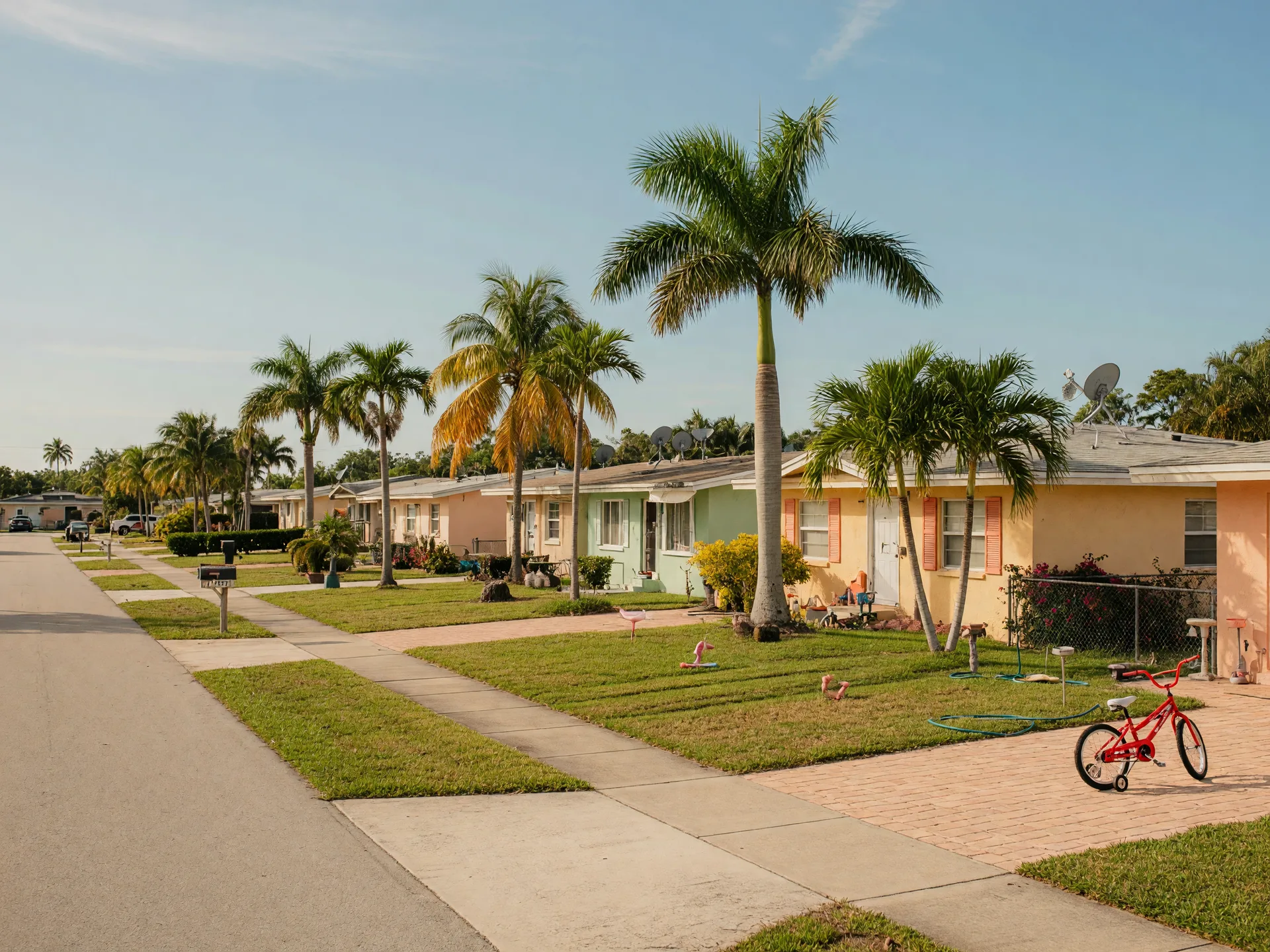 Quiet residential street in Boynton Beach with affordable single-family homes, palm trees, and well-maintained lawns