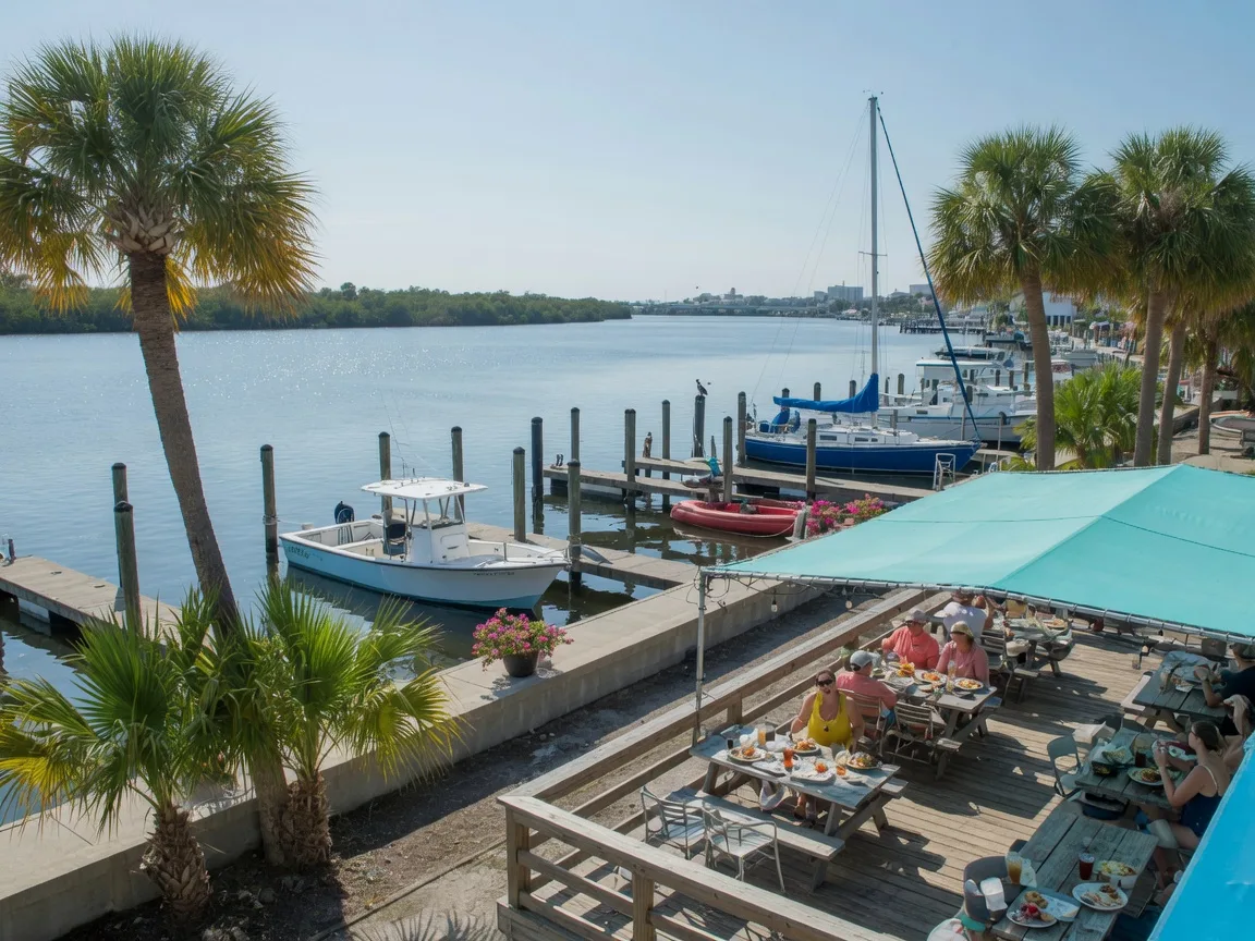 Waterfront dining along the Manatee River in downtown Bradenton, with an open-air restaurant deck beside a marina and boats at their slips
