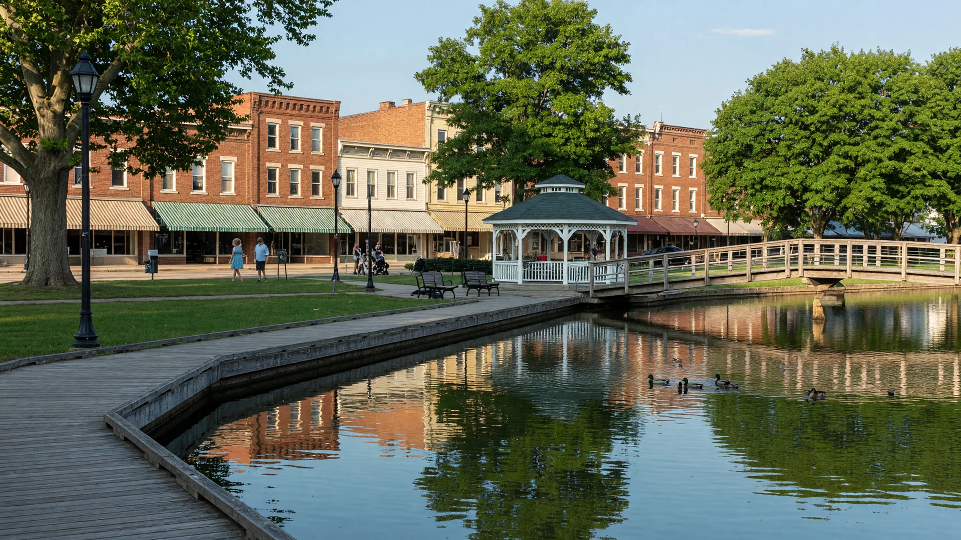 The Mill Pond and boardwalk with Main Street storefronts in downtown Brighton, Michigan