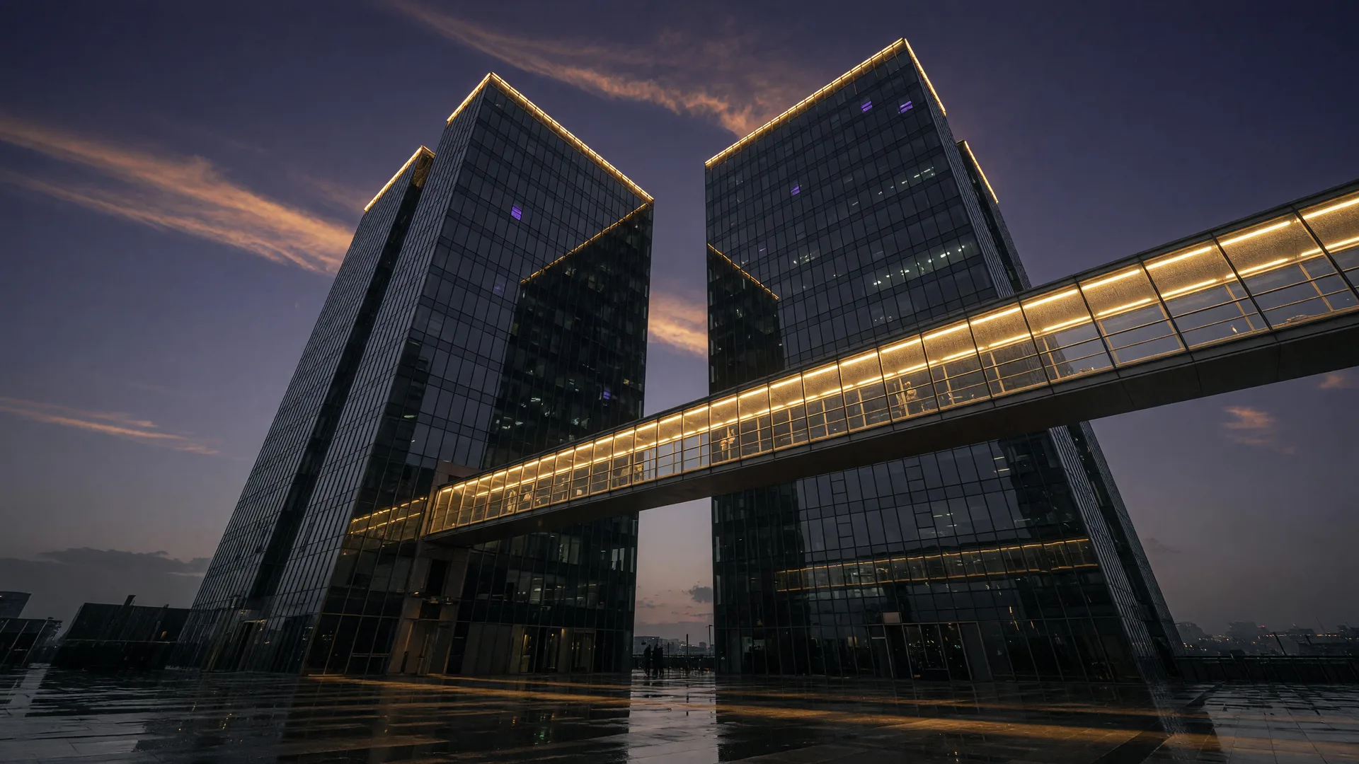 Two dark glass skyscrapers at dusk connected by a glowing golden bridge, representing the closed Real + RE/MAX merger and the fee increase every agent needs to plan around