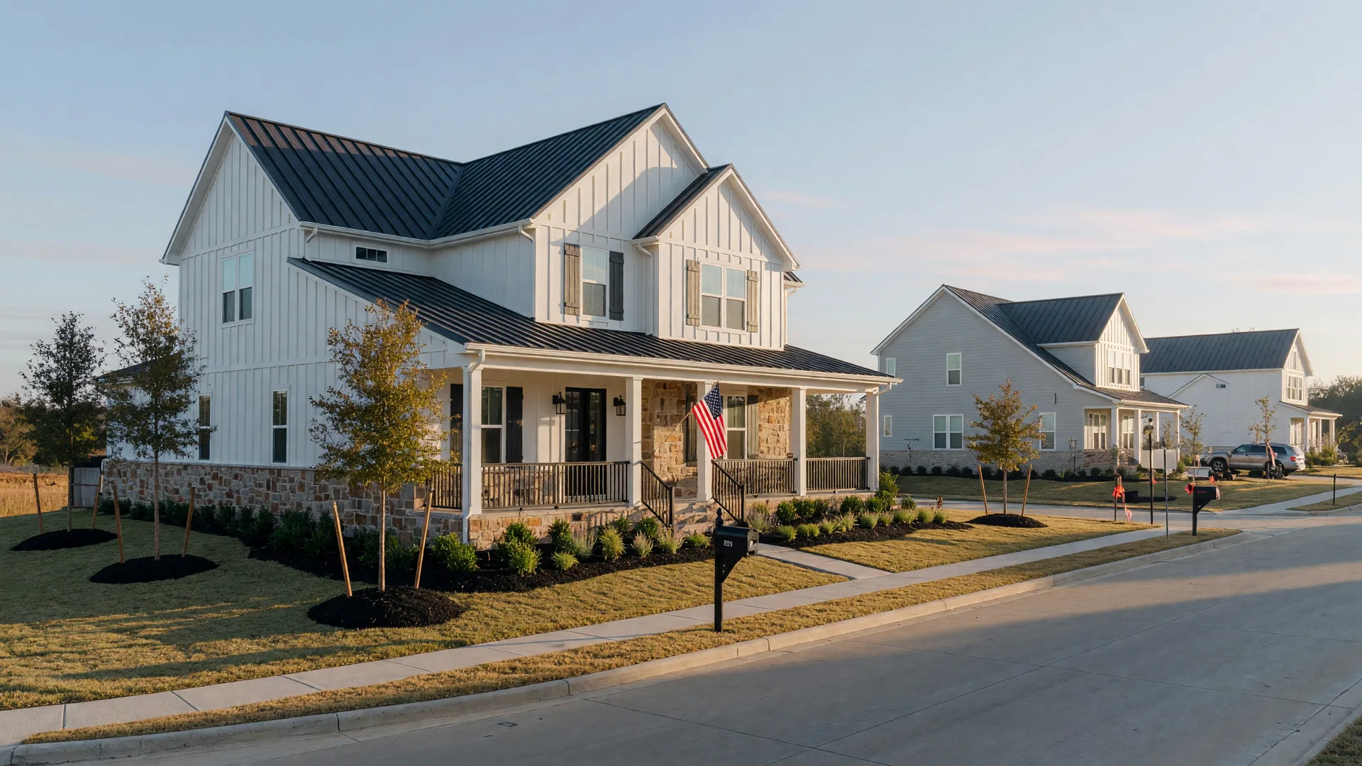 A new modern farmhouse-style home in a North Texas master-planned community with an American flag beside the front door on a clear autumn morning