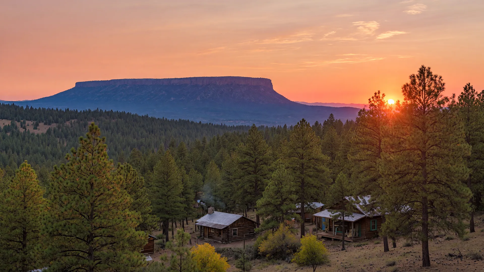 Golden hour sunset over Payson and the Mogollon Rim, with pine-covered hills and a warm late summer sky
