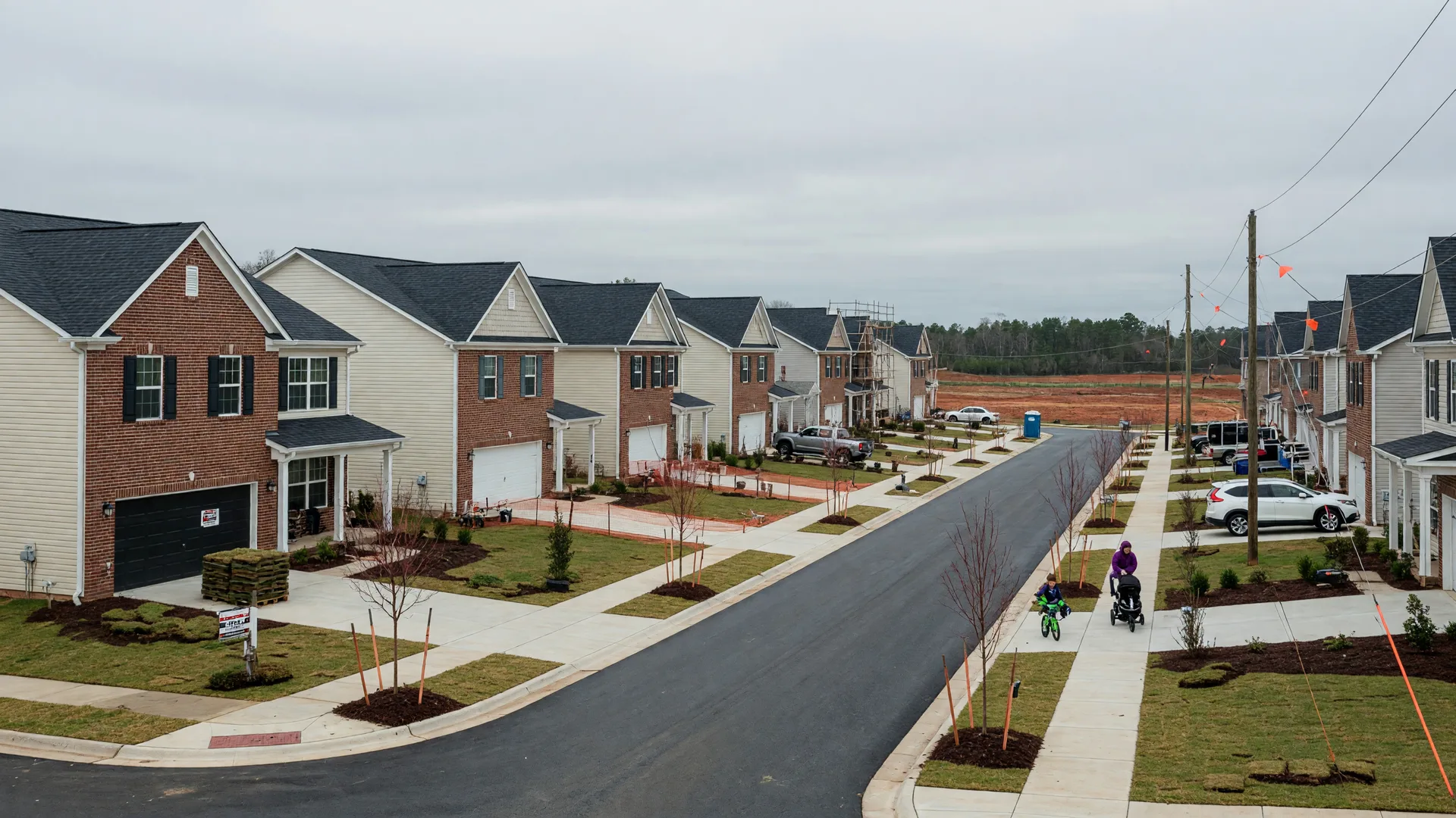 Newly built brick and siding homes on a tree-lined subdivision street in Indian Land SC