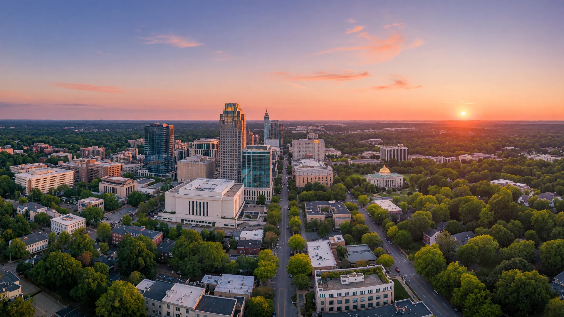Aerial view of downtown Raleigh, North Carolina at golden hour with lush oak canopy