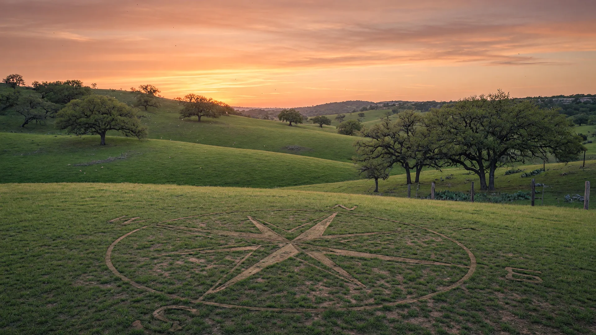 Texas Hill Country landscape at golden hour with rolling hills, live oak trees, and a subtle compass motif representing new beginnings for military families relocating to JBSA