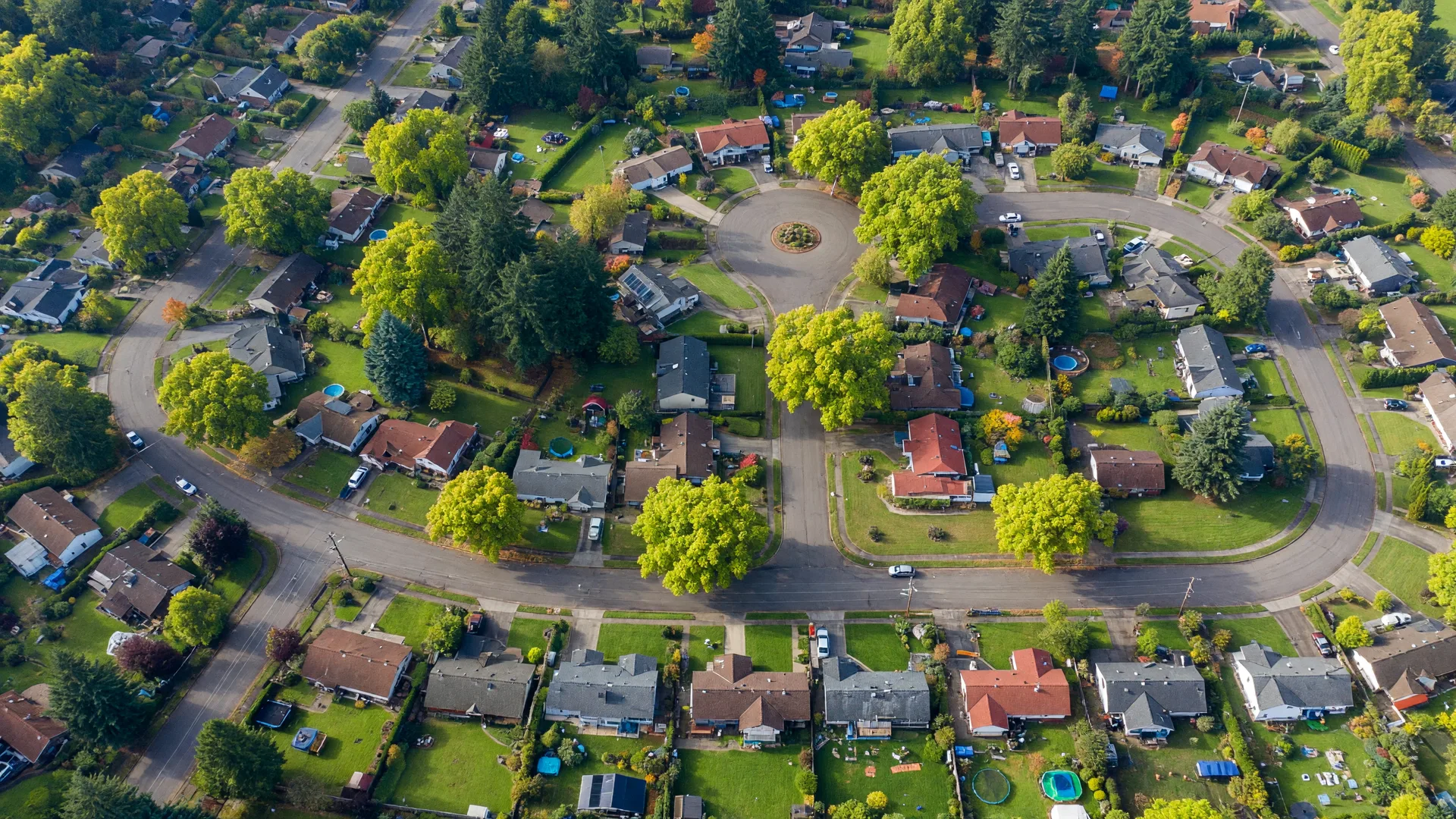 Aerial view of a leafy Willamette Valley neighborhood with curving streets and tree canopy