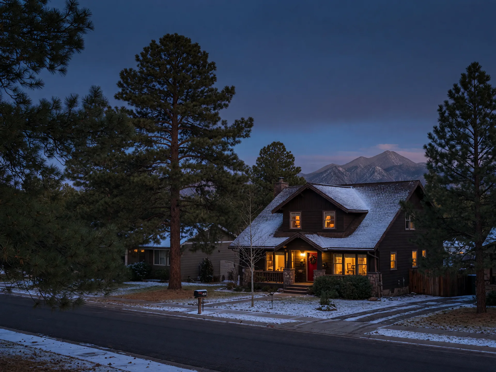 An illustrative mountain home among pines at blue hour; current photos of this listing live on its own site