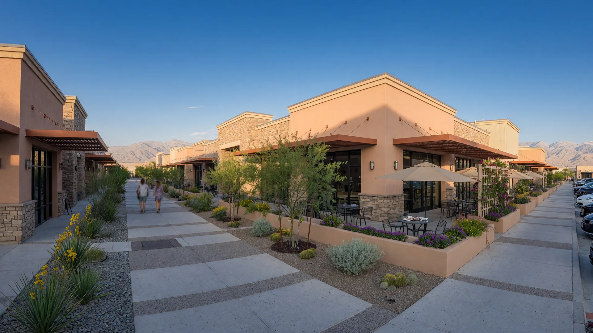 A new walkable town-center street at the heart of a master-planned community in south Henderson, with cafe patios, shops and desert landscaping in morning light