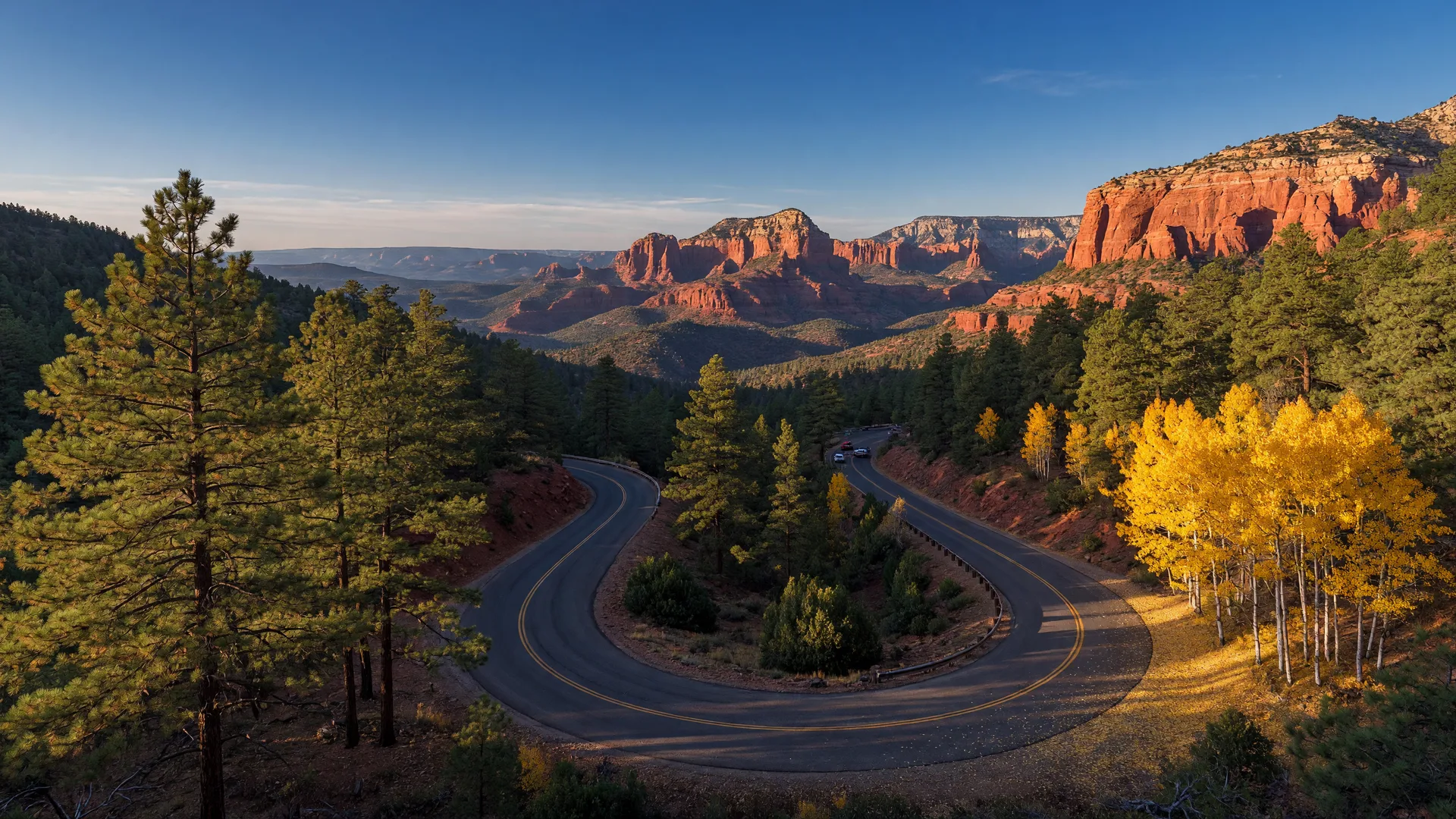 A winding mountain road dropping from Flagstaff's ponderosa pines toward the red-rock canyon country to the south