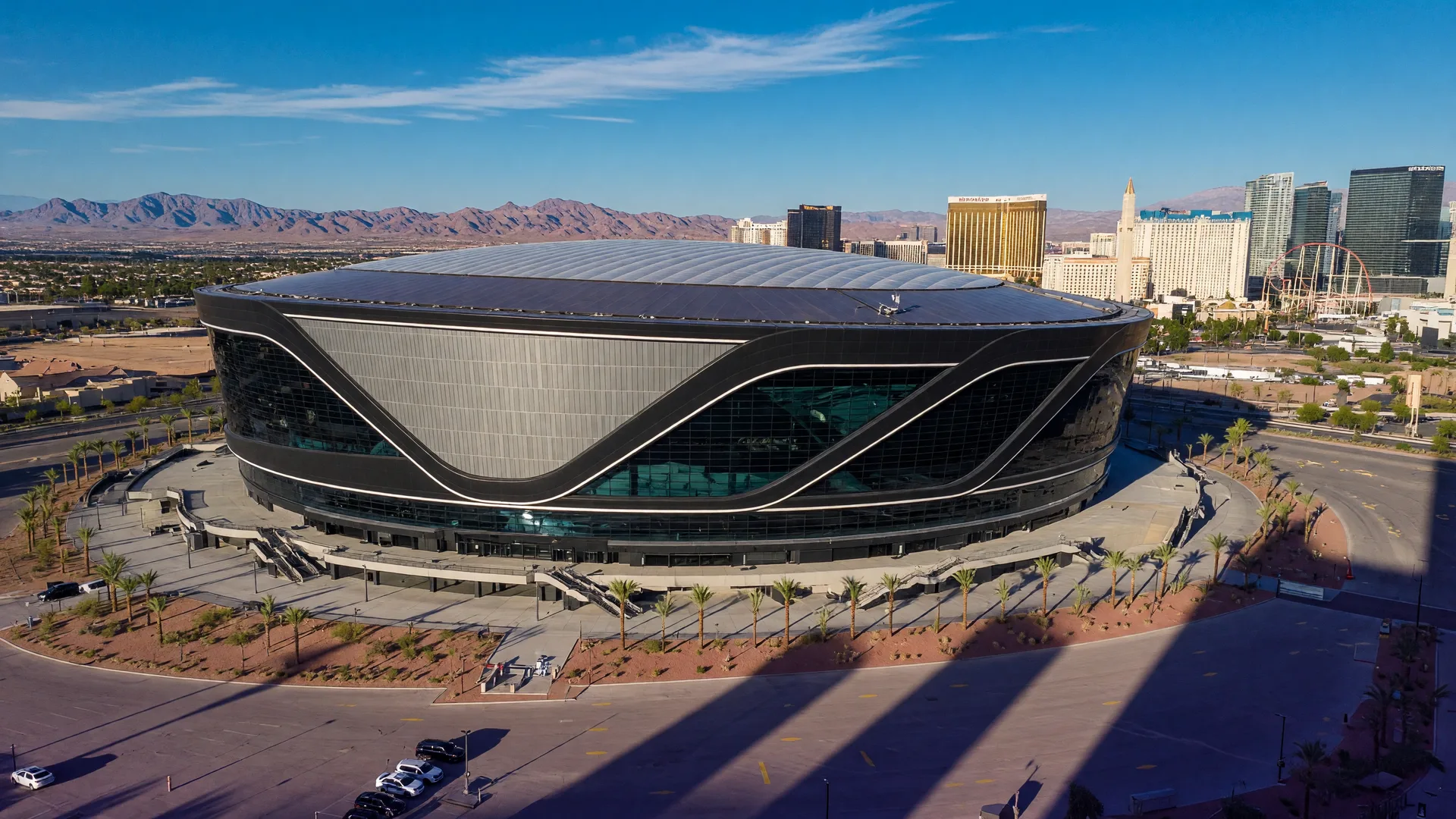 Allegiant Stadium in Las Vegas on a sunny afternoon with surrounding Strip skyline