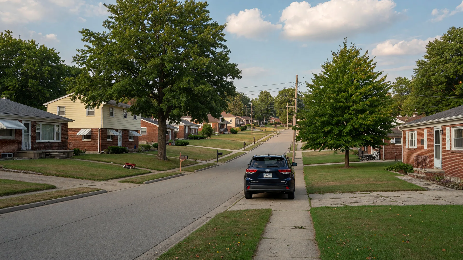 Quiet mid-century suburban street in Northeast Ohio on a warm summer afternoon