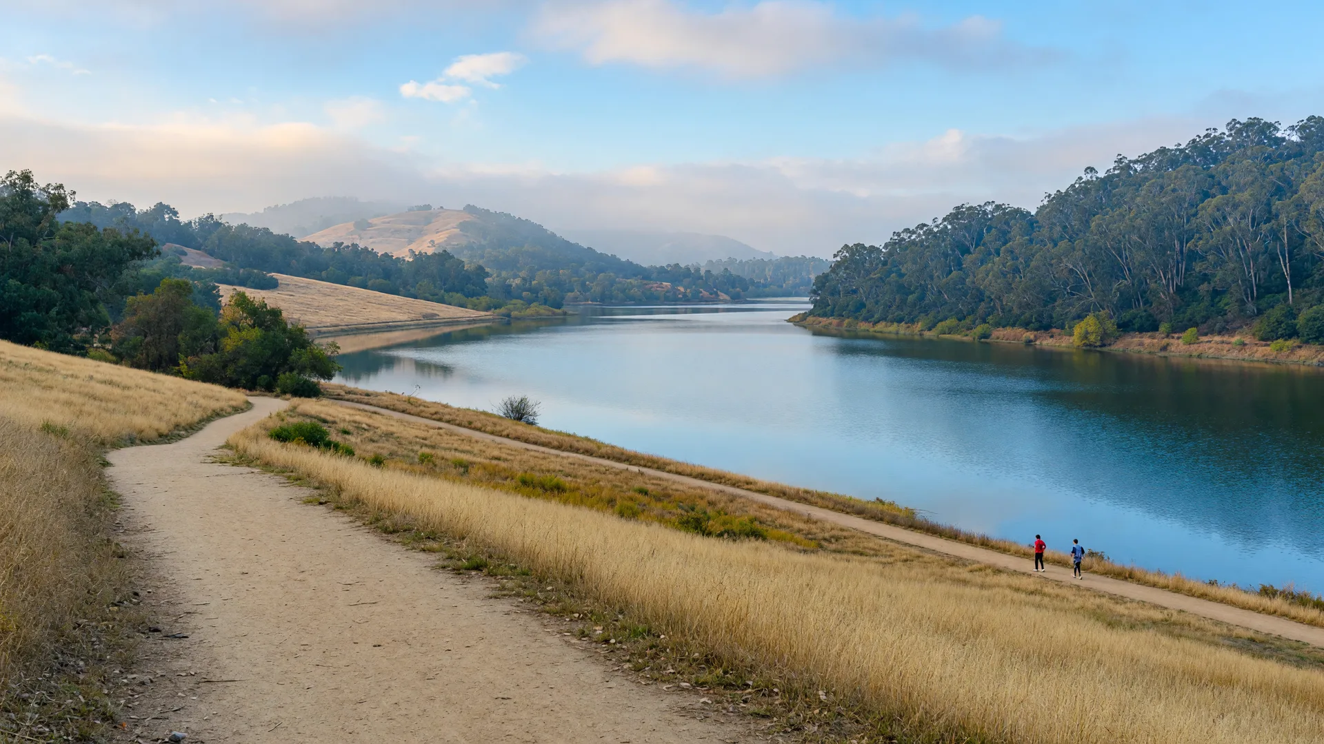 Lake Chabot Regional Park at morning with a calm lake, golden hills, and a trail along the shore