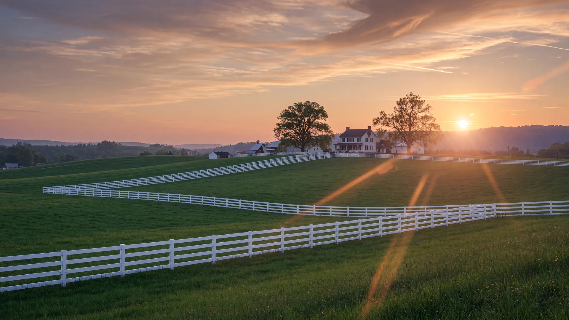 Rolling Kentucky bluegrass horse country at golden hour with white fencing and a farmhouse on the horizon