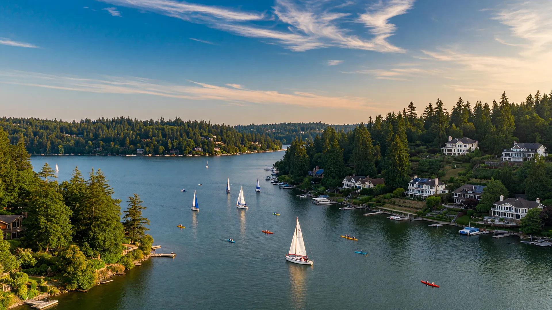 Scenic view of Oswego Lake in Lake Oswego, Oregon with sailboats on the water and hillside homes in the background