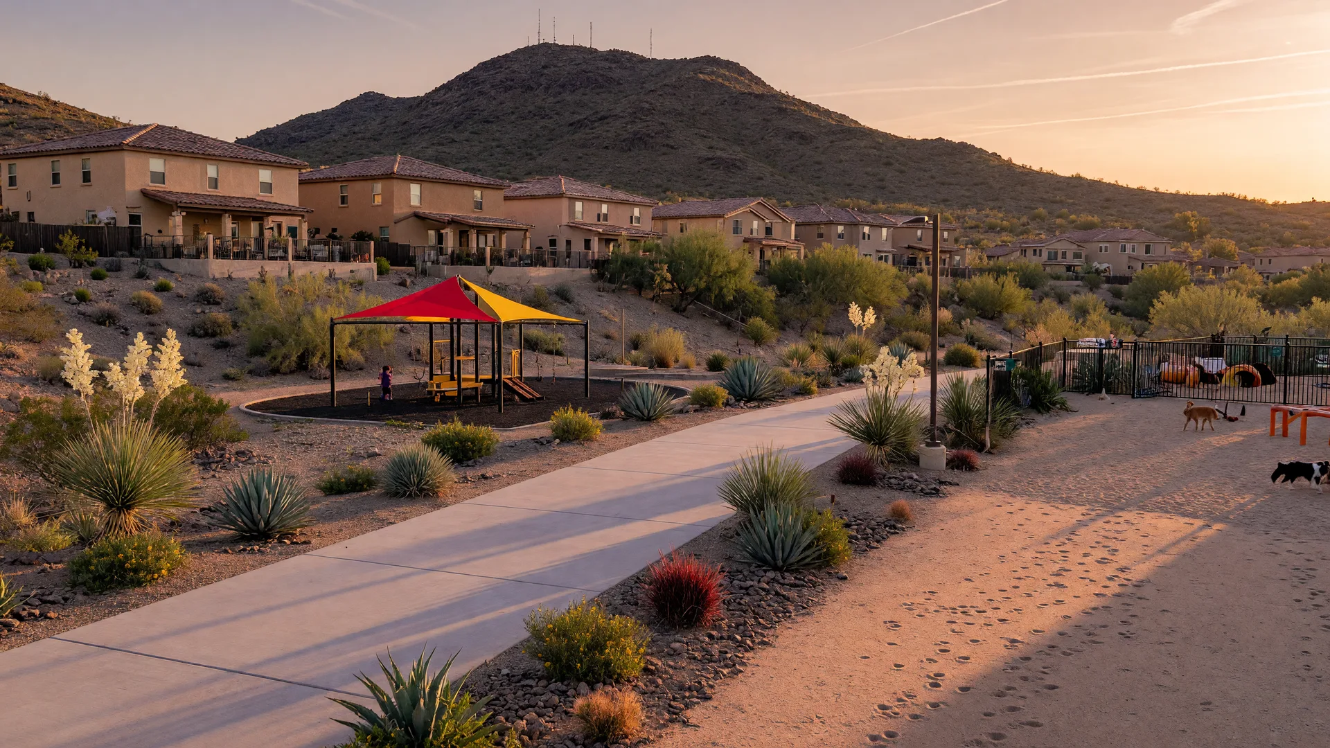 A desert-foothills walking trail with a dog park and playground in a MacDonald Ranch style community, with tile-roof homes and Black Mountain in the background