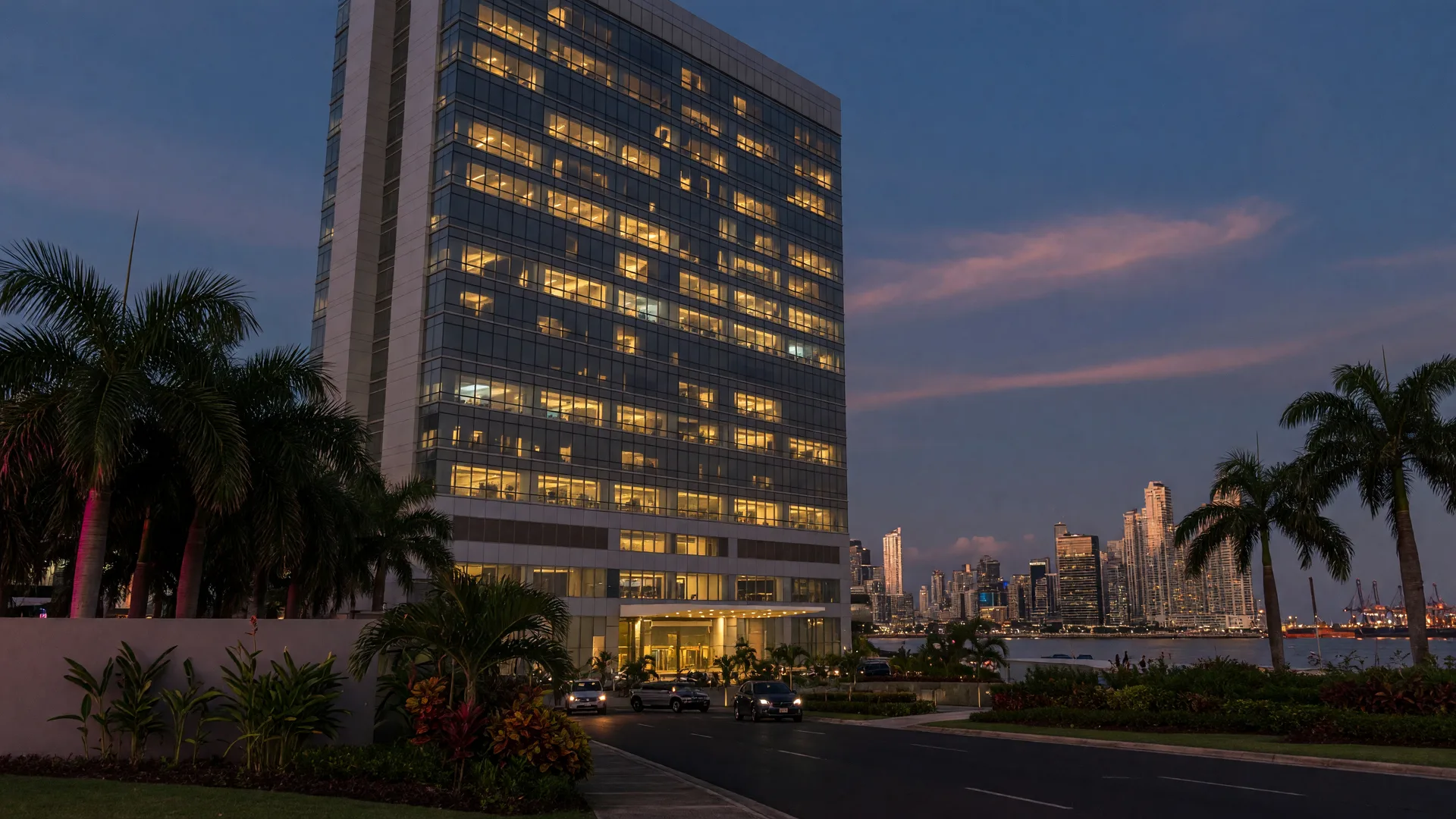 Modern private hospital tower in Panama City at dusk with palm trees in the foreground
