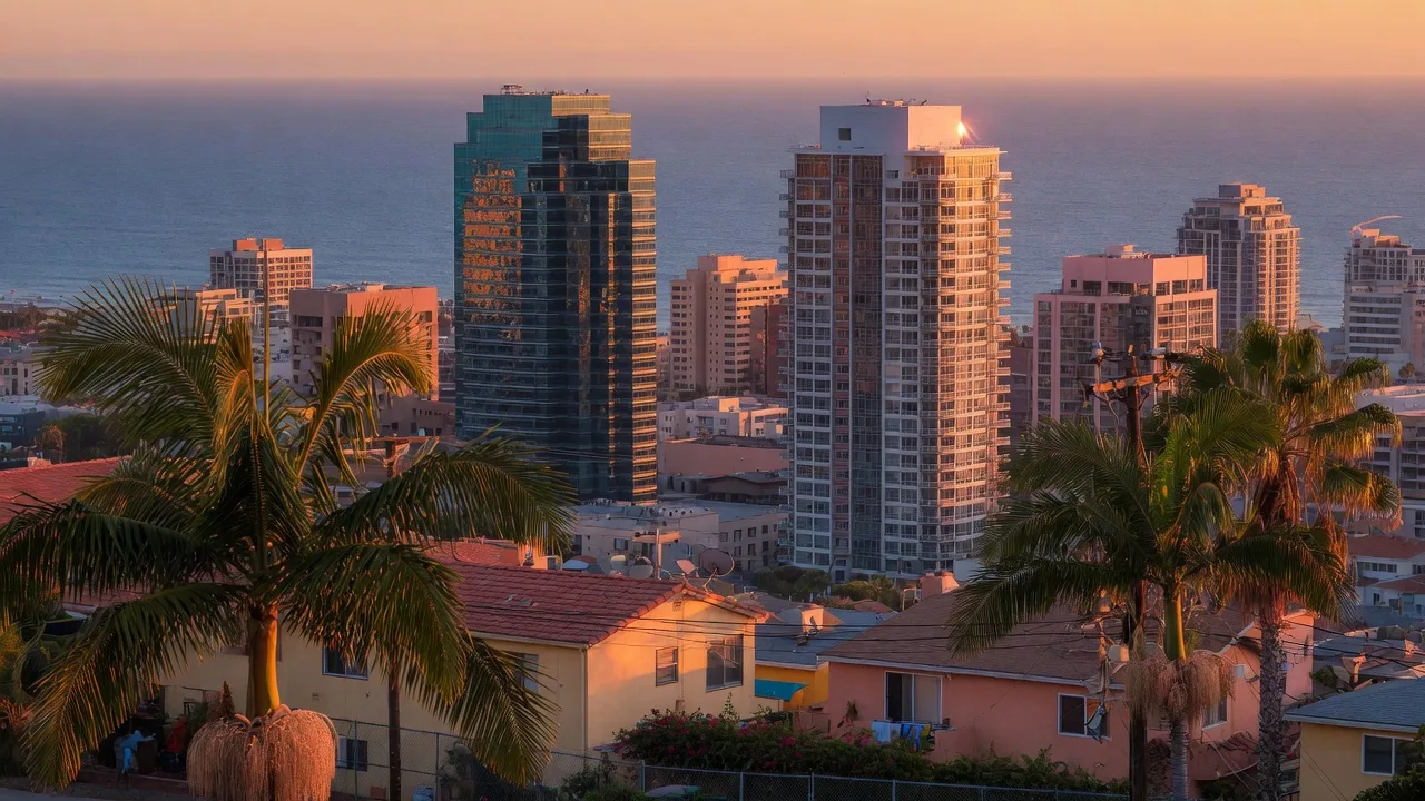 San Diego financial district skyline at golden hour with palm trees and Pacific Ocean horizon