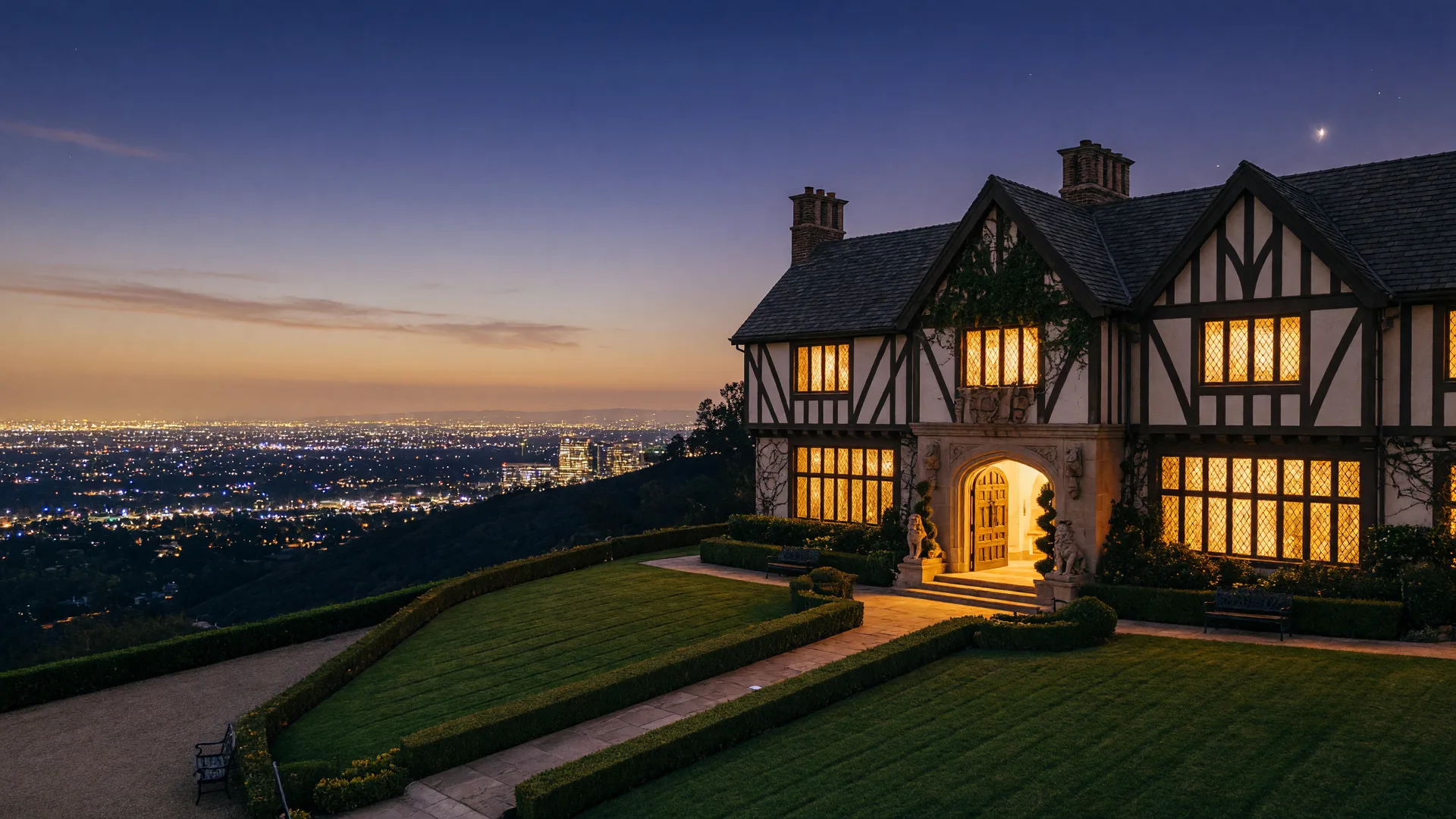 The Summit House at dusk in Raymond Hills: a stately Tudor-style restaurant perched on the Bastanchury ridge with panoramic Orange County city lights glowing below
