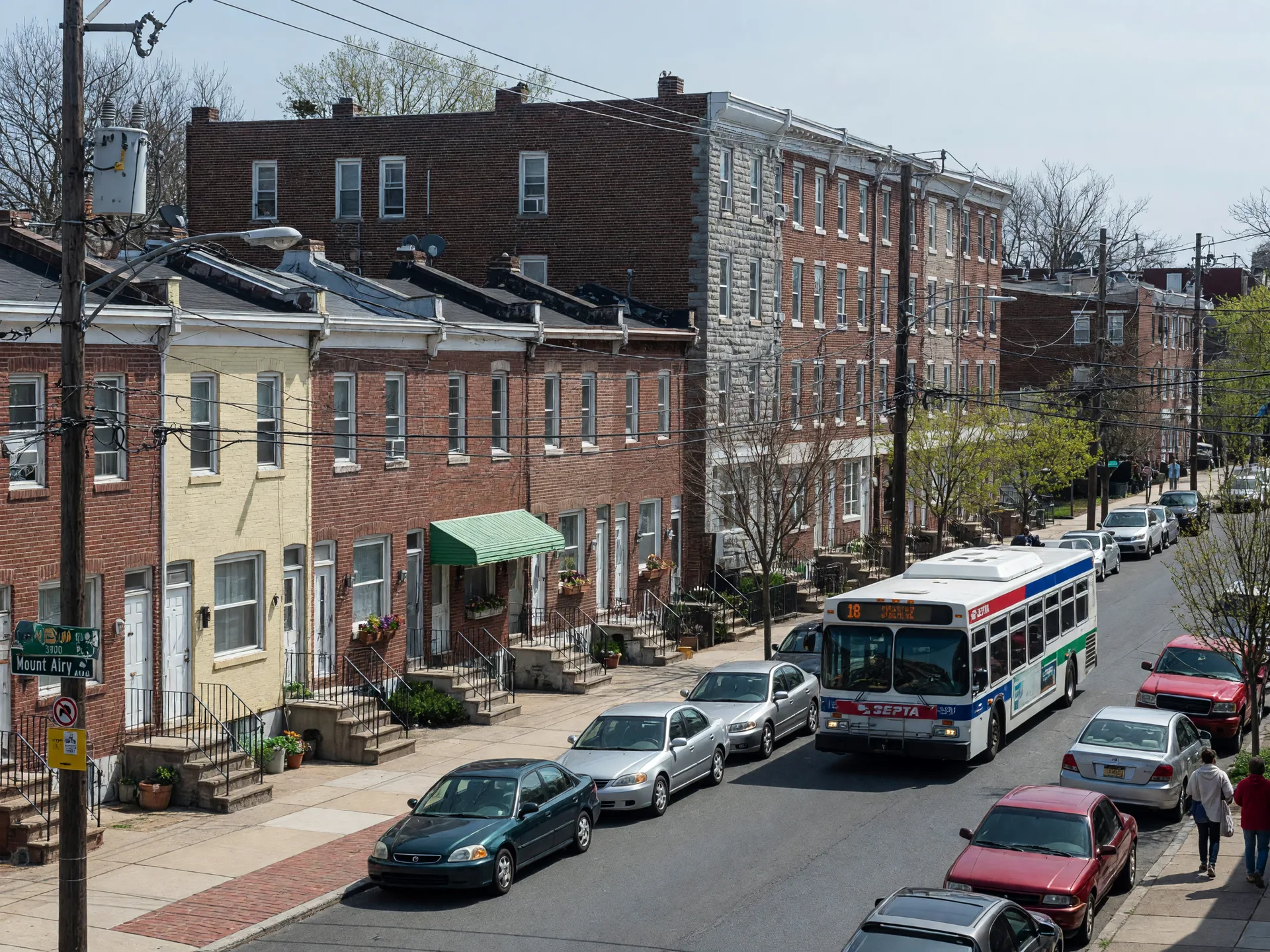 Brick rowhomes and twin houses lining East Mount Airy Avenue near the neighborhood's eastern entrance
