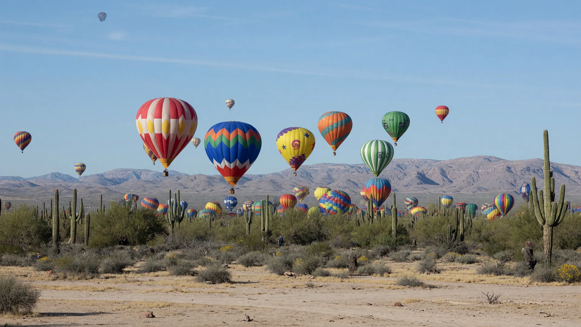 Hot air balloons glowing at sunrise over a small Arizona town near Litchfield Park