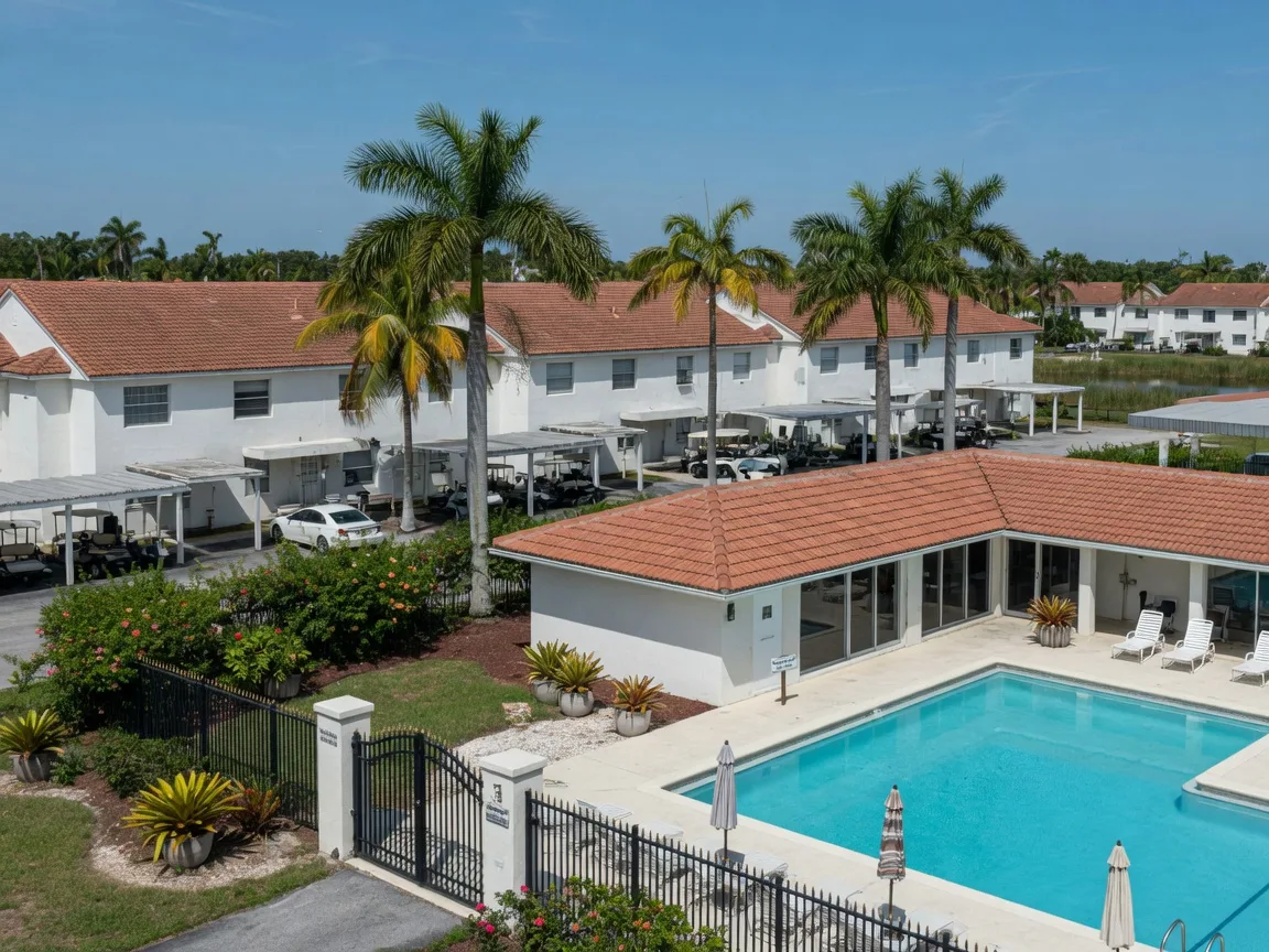 Gated low-maintenance community in Palm Beach County with villas, palm trees, and a pool and clubhouse.