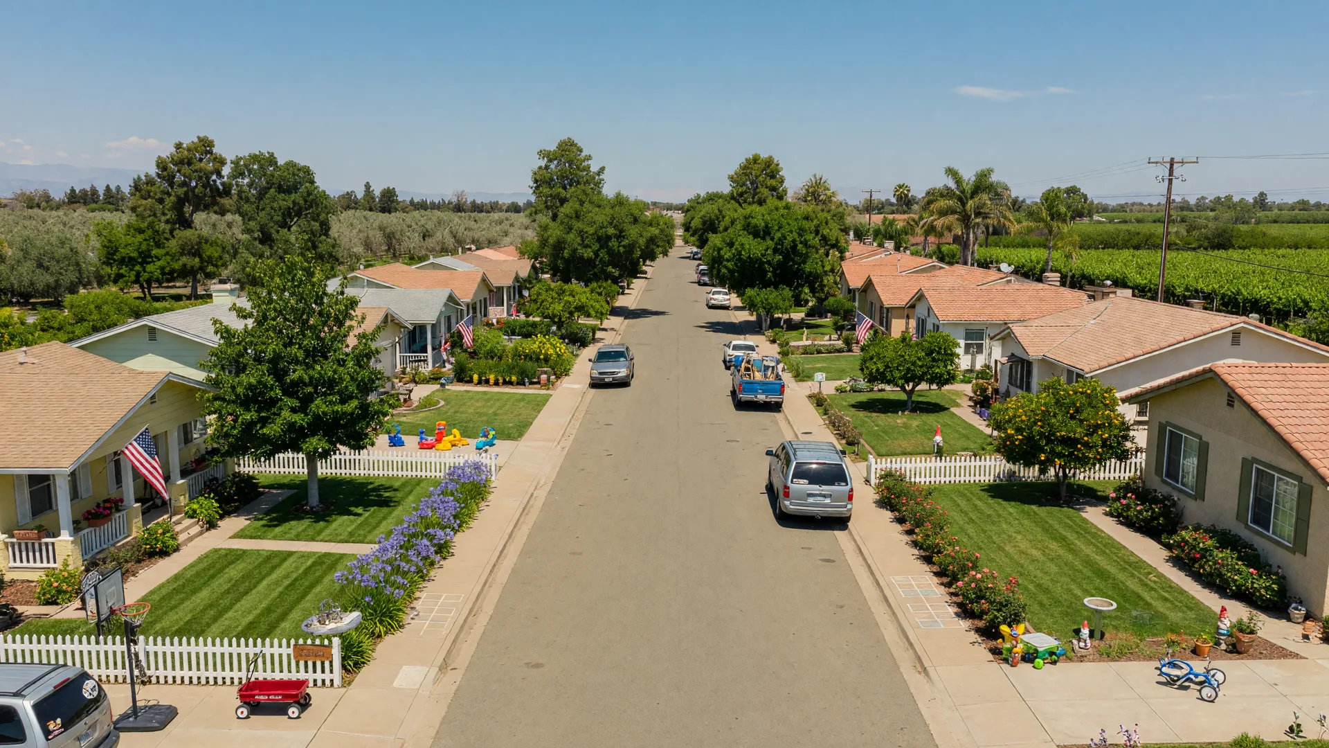 Quiet residential street in Livingston, California with well-maintained single-family homes, mature shade trees, and a peaceful neighborhood atmosphere