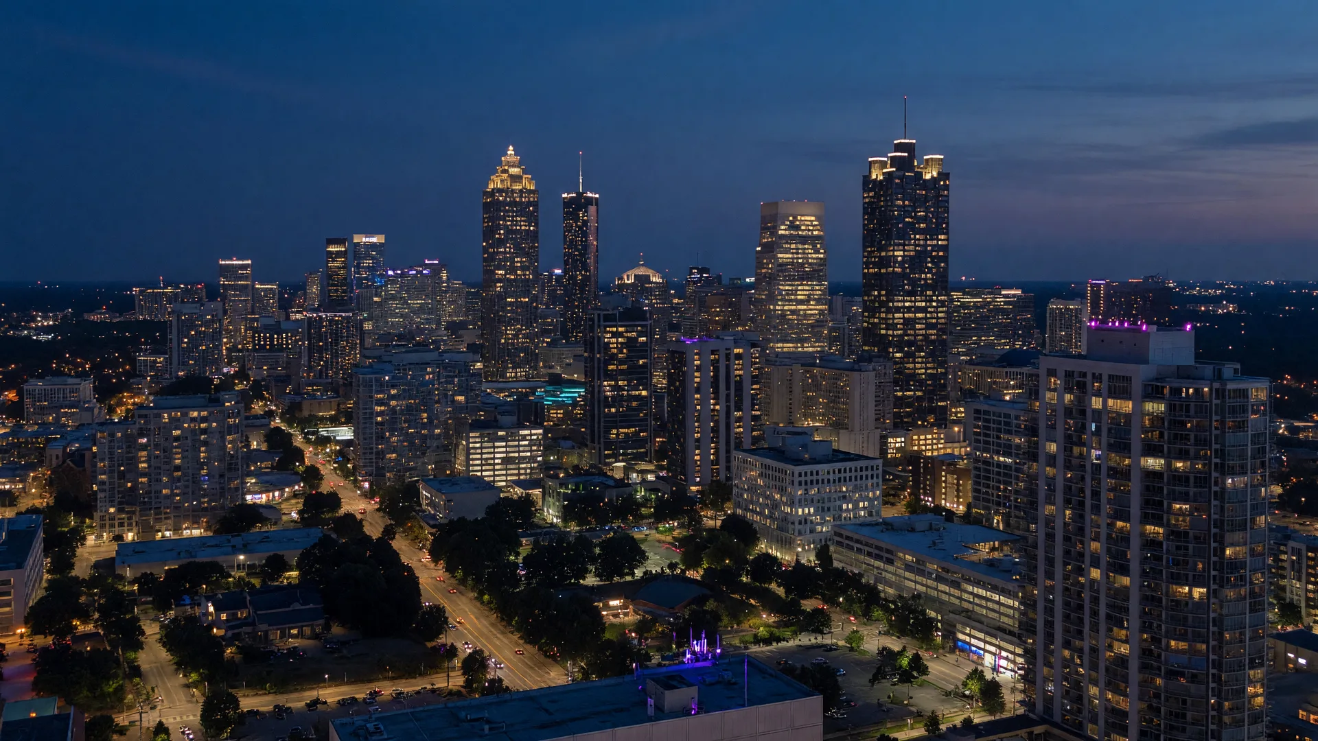 Atlanta skyline at blue hour with the midtown and downtown towers lit against a navy dusk sky